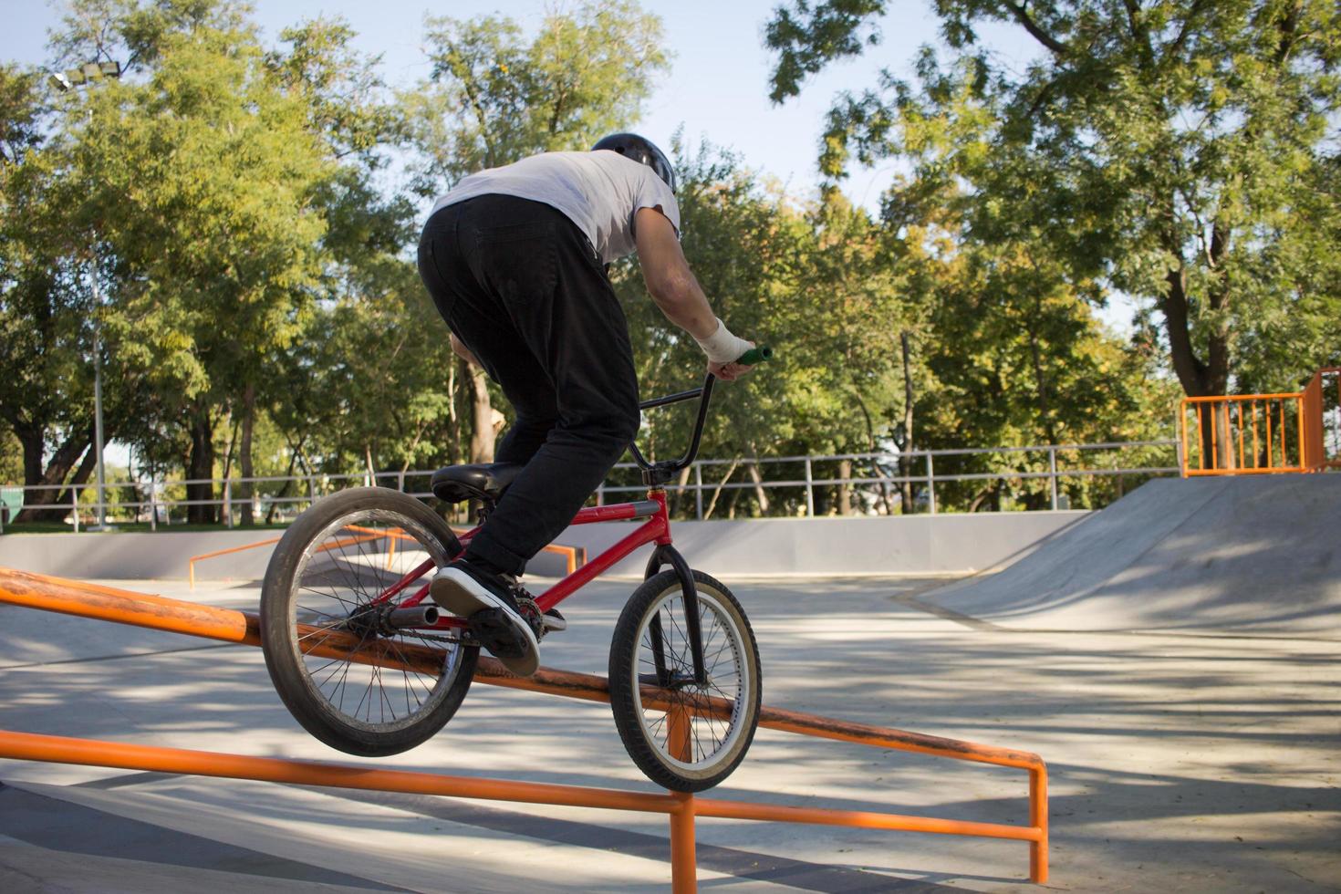 Group of young people with bmx bikes in skate plaza, stunt bicycle riders in skatepark photo