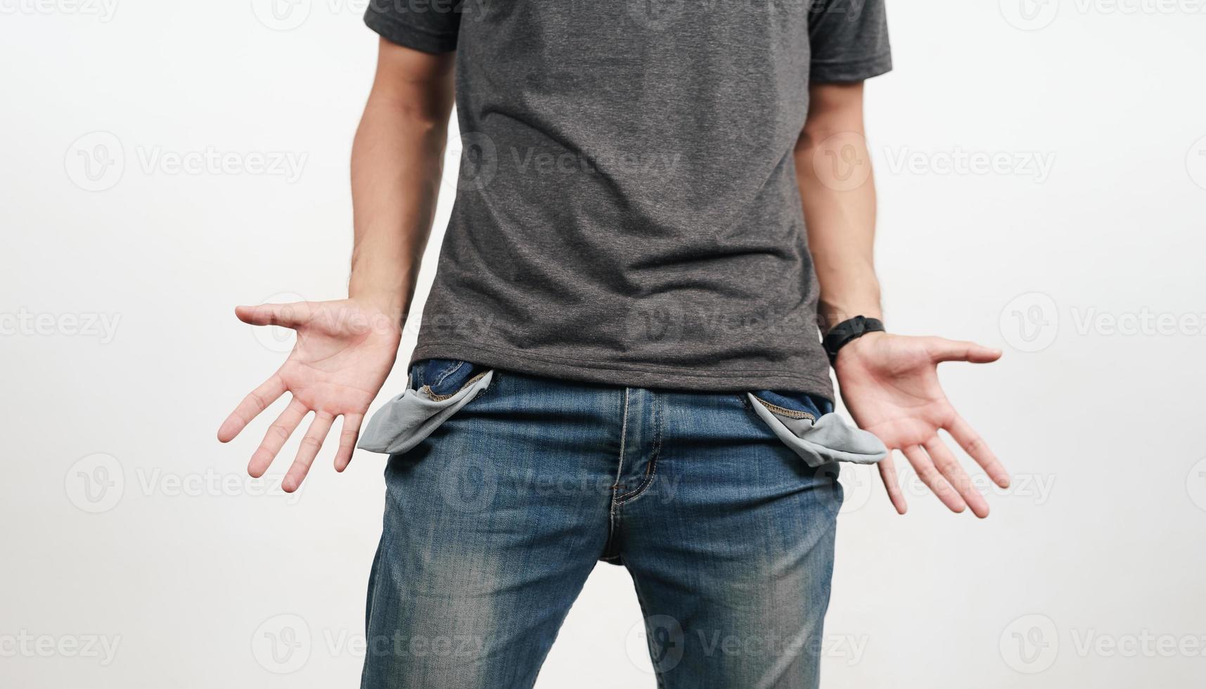 Man turning out the jean pocket to showing empty pocket. bankrupt, bad economy, no money concept. photo