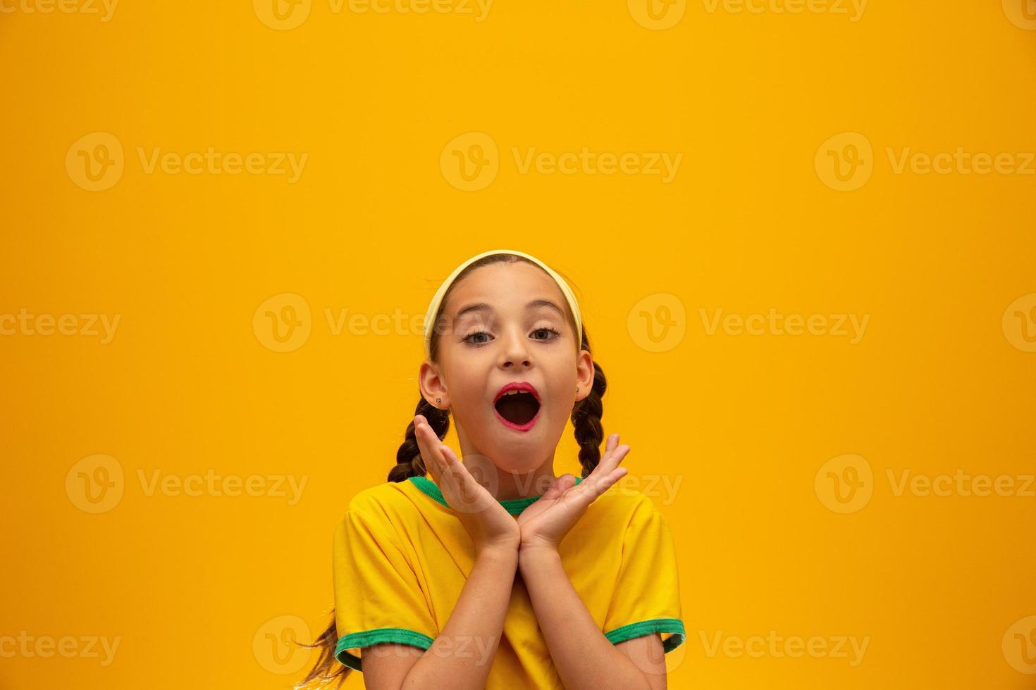 hincha de fútbol, equipo de brasil. Copa Mundial. hermosa niña animando a su equipo con fondo amarillo foto