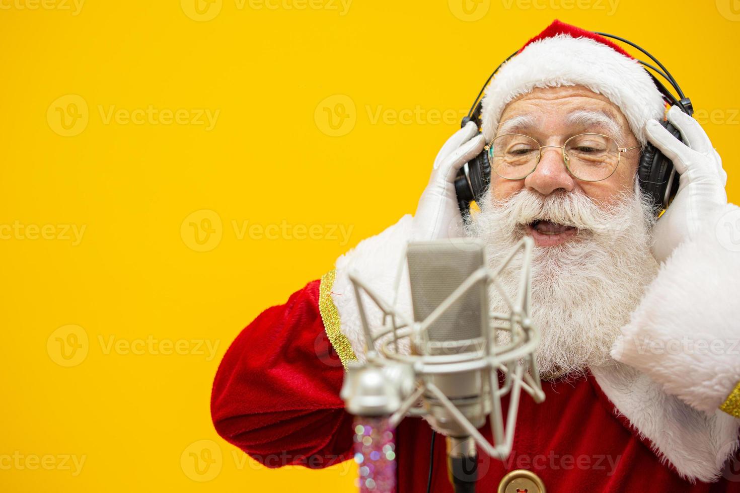 santa claus cantando o hablando en un micrófono de estudio. Feliz Navidad. locutor. locutor. promoción. concepto de música navideña. foto