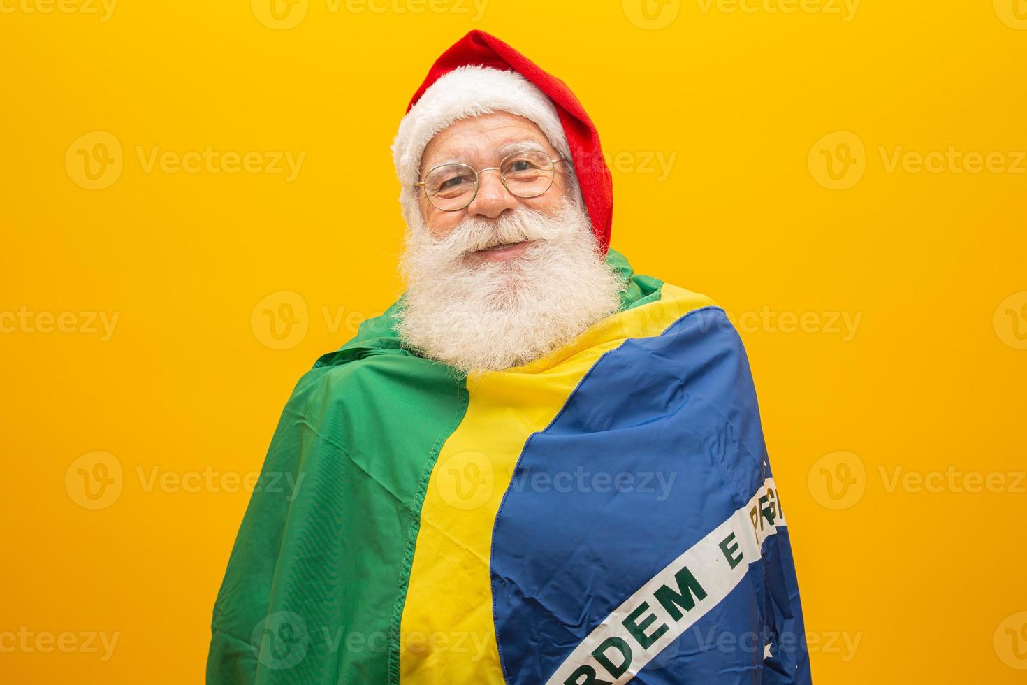 santa claus es fanático de brasil. partidario de santa claus del equipo brasileño. campeonato deportivo santa claus sosteniendo la bandera brasileña. partido de fútbol. foto