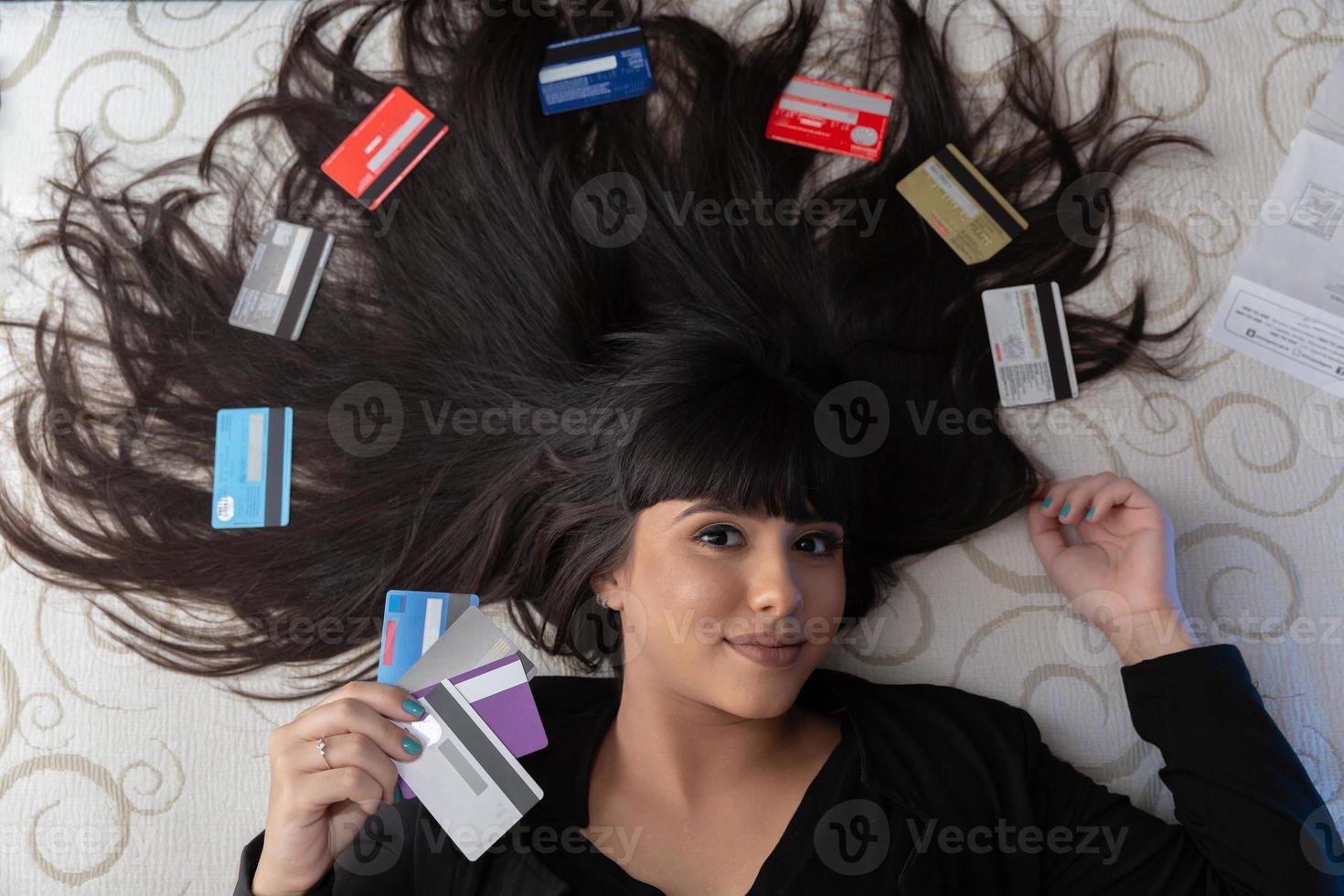 Beautiful woman with multiple credit cards on the bed. Plastic money, electronic money and digital money will change the global marketing in the near future. Concept of rich woman. photo