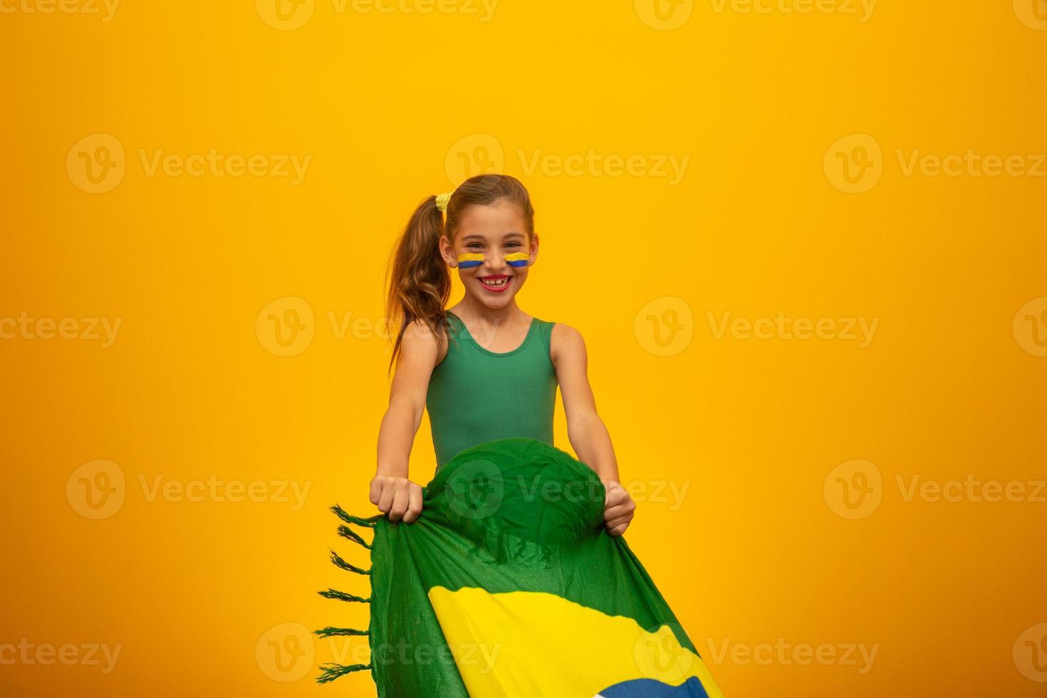 hincha de fútbol, equipo de brasil. Copa Mundial. hermosa niña animando a su equipo con fondo amarillo foto