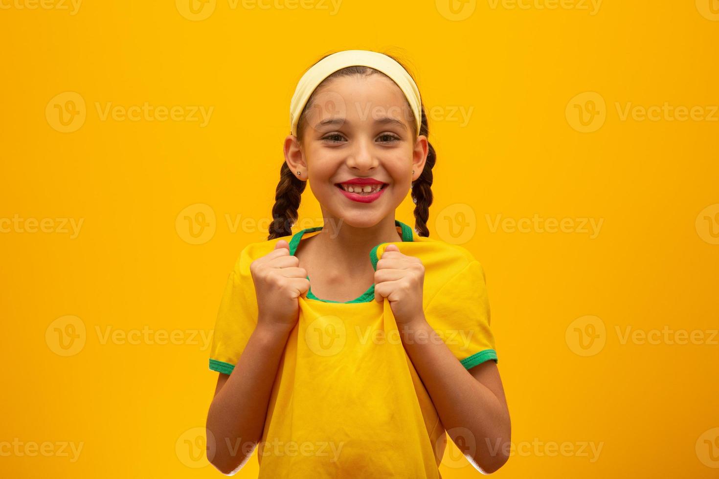 hincha de fútbol, equipo de brasil. Copa Mundial. hermosa niña animando a su equipo con fondo amarillo foto