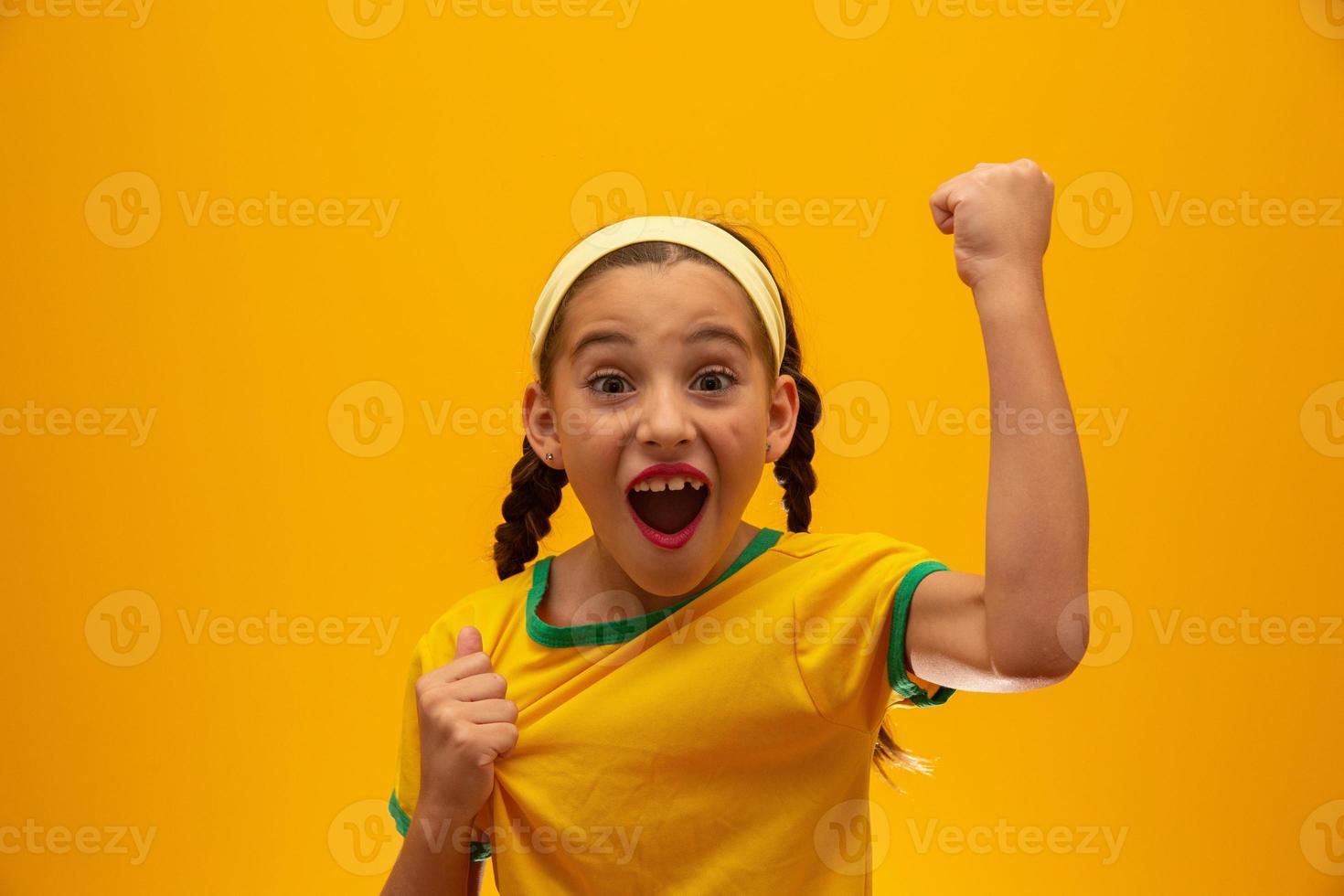 hincha de fútbol, equipo de brasil. Copa Mundial. hermosa niña animando a su equipo con fondo amarillo foto