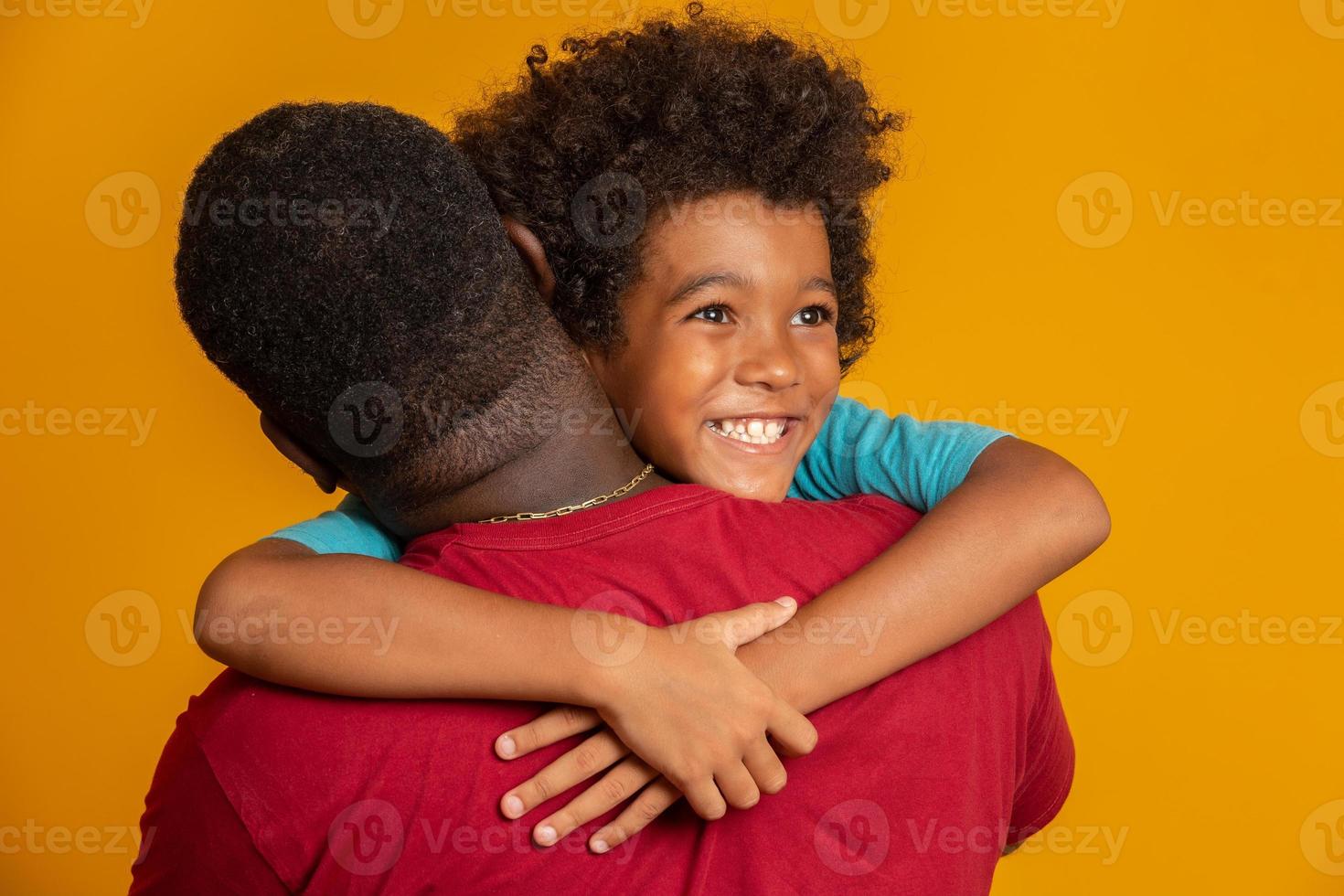 padre africano e hijo jugando al superhéroe durante el día. gente divirtiéndose fondo amarillo. concepto de familia amistosa. foto