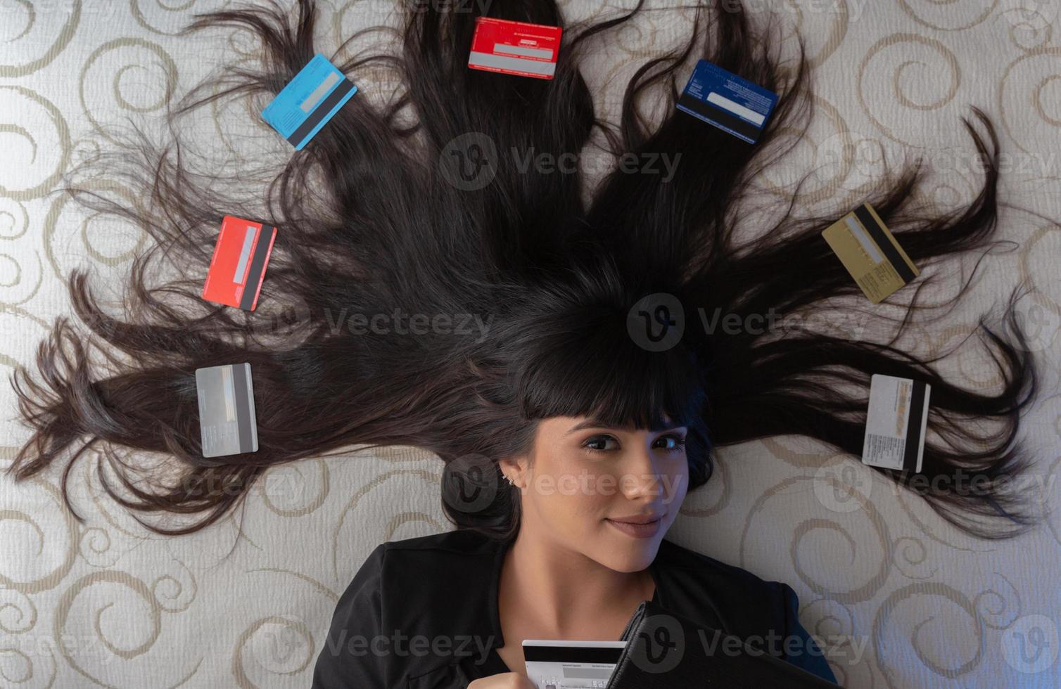 Beautiful woman with multiple credit cards on the bed. Plastic money, electronic money and digital money will change the global marketing in the near future. Concept of rich woman. photo