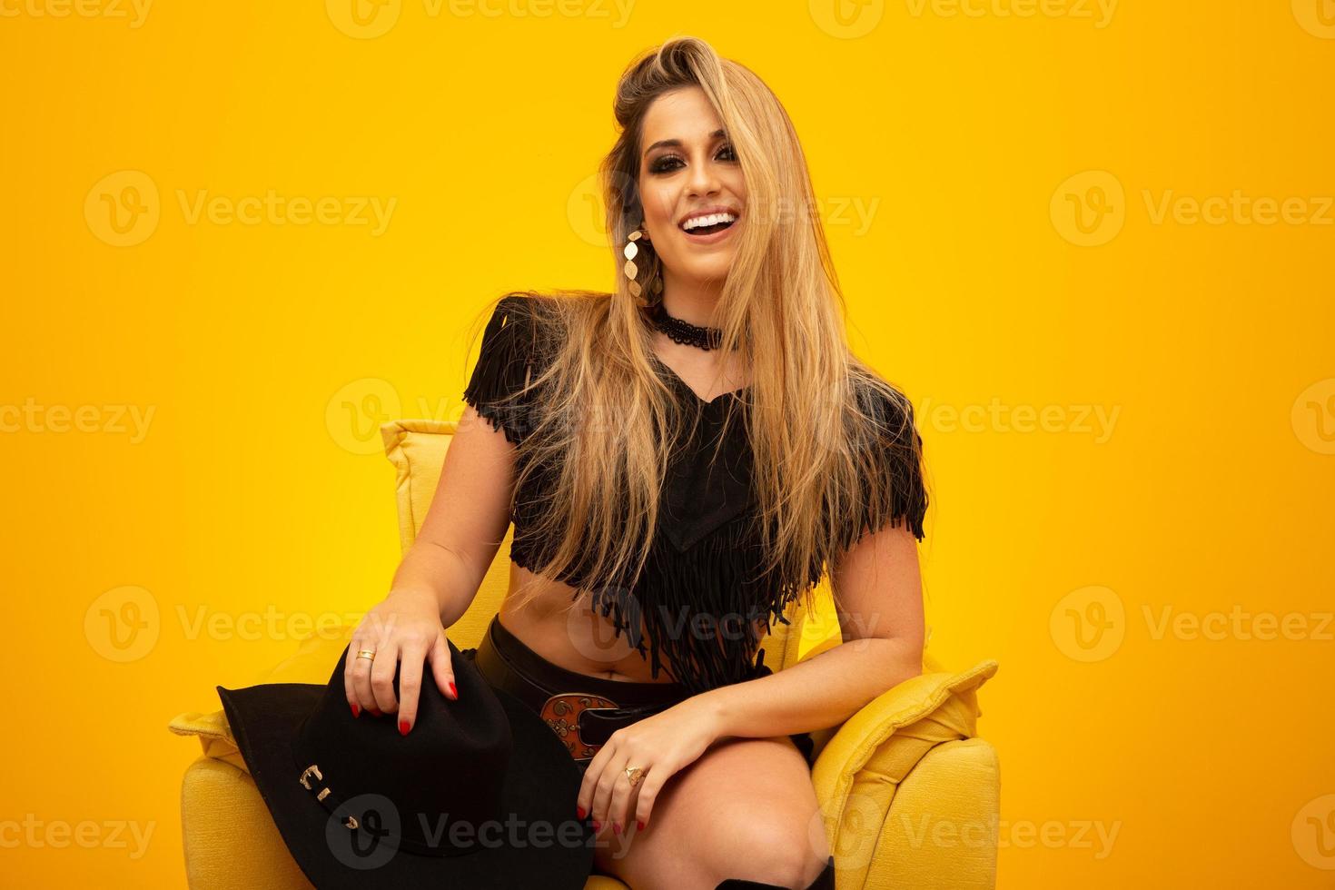 Happy sexy cowgirl on yellow background photo