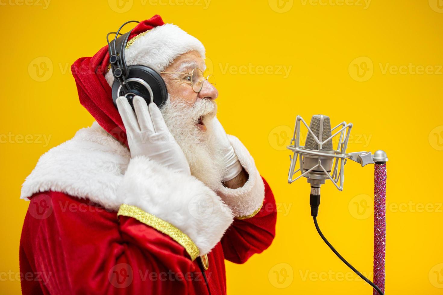 Santa Claus singing or speaking in a studio microphone. Merry Christmas. Broadcaster. Announcer. Promotion. Christmas music concept. photo