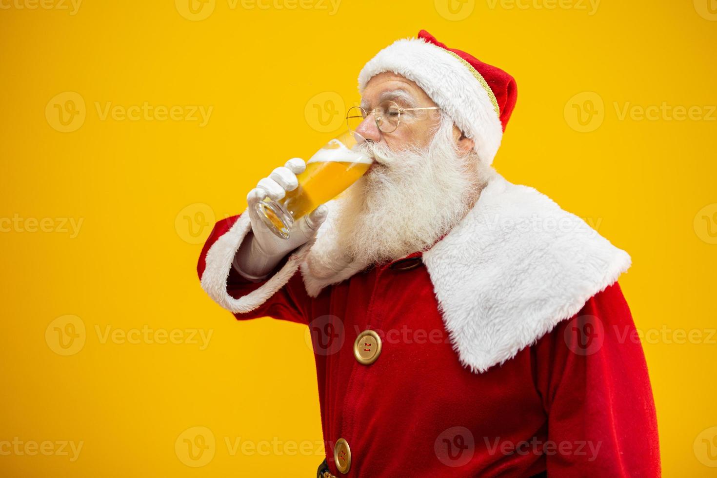 Santa Claus drinking a glass of beer. Rest time. Alcoholic drink at the holidays. Drink with moderation. Craft beer. Merry Christmas. photo