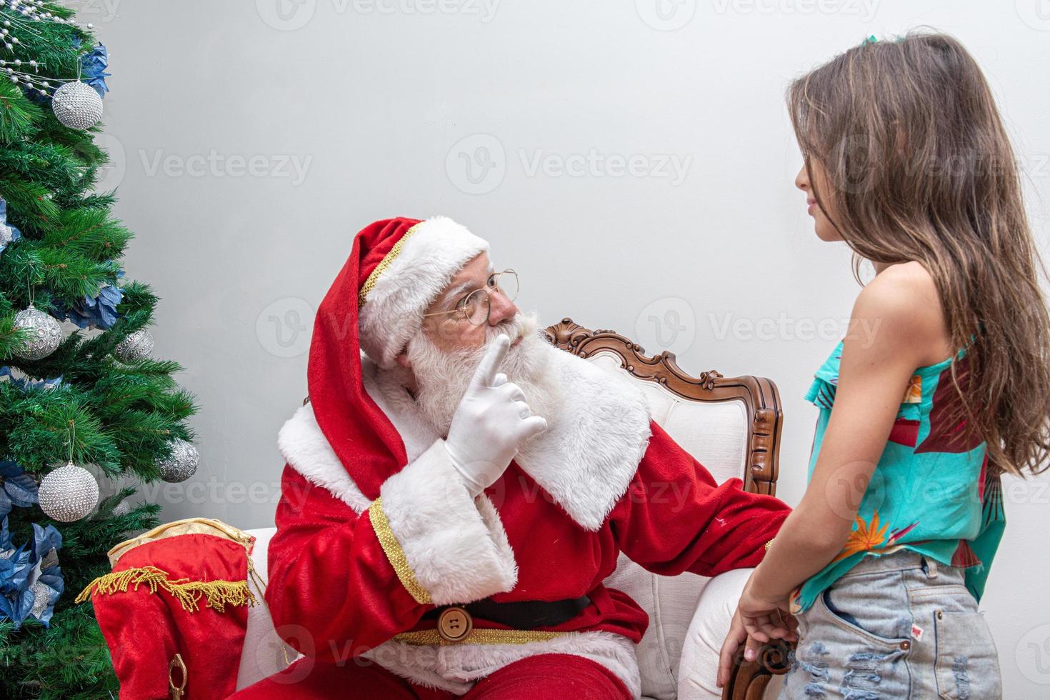 niña sentada en una caja de regalo grande mientras juega con santa claus.  celebrar las vacaciones de navidad y la fiesta de acción de gracias.  13183685 Foto de stock en Vecteezy