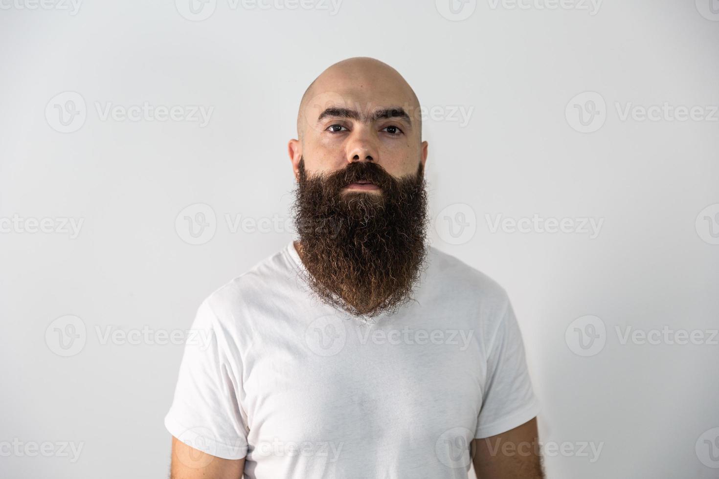 Bearded man looking at the camera. Concept of masculinity and care with the beard. Pointing with finger, approving or indicating. photo
