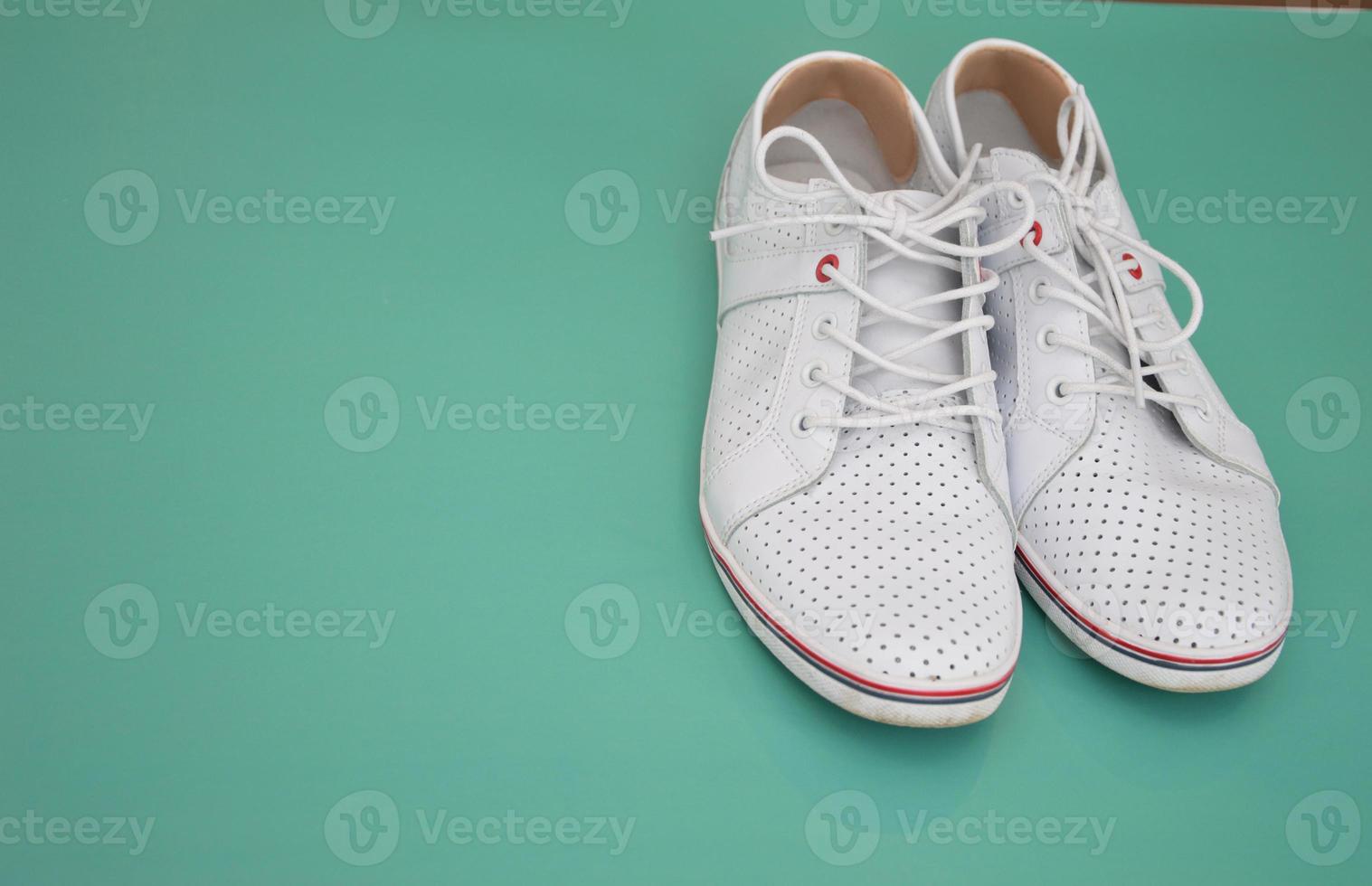 A pair of white sneakers on a colored background, top view. Shoes for walking, running, walking. Fashion footwear. Free space for text. photo