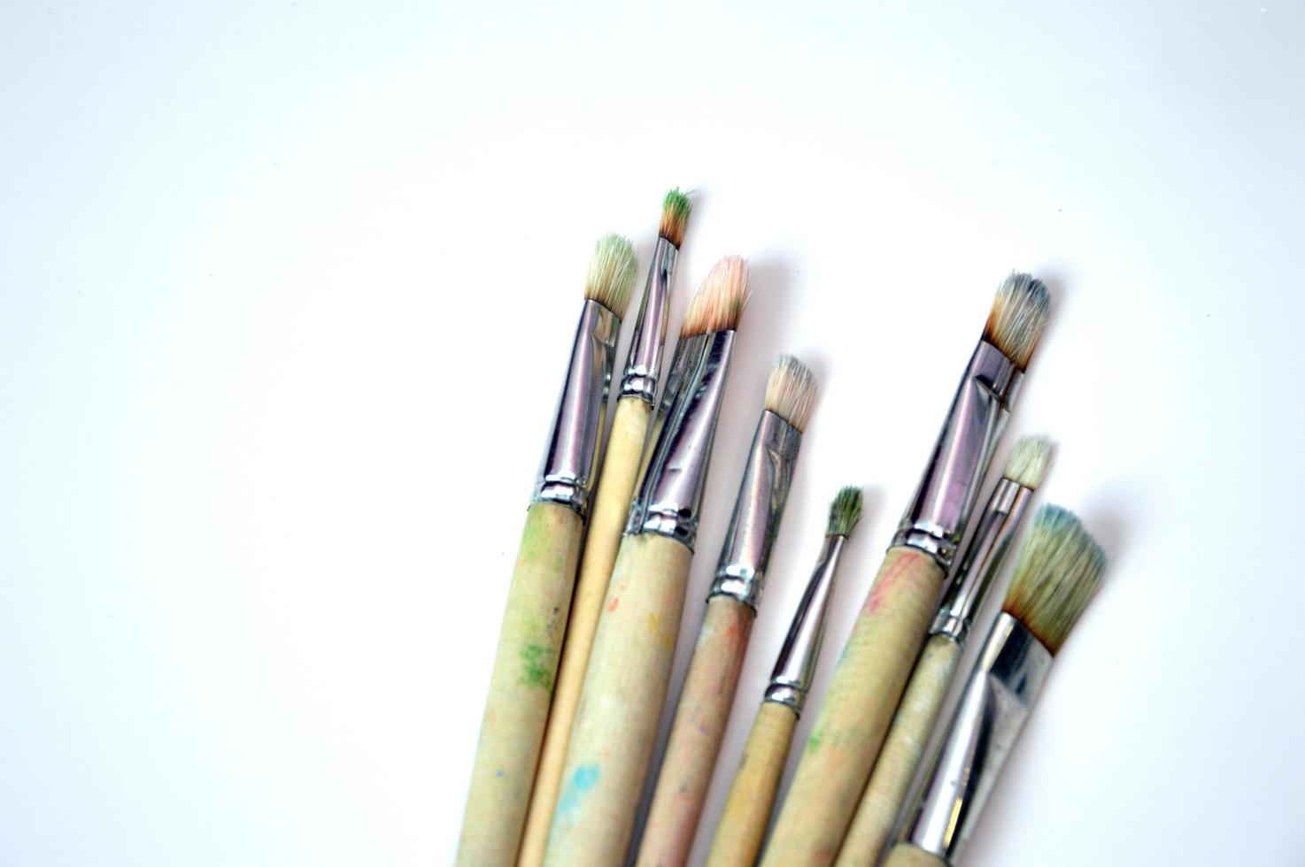 Brushes of different sizes with wooden handles and natural bristles on a white background. Free space for text. photo