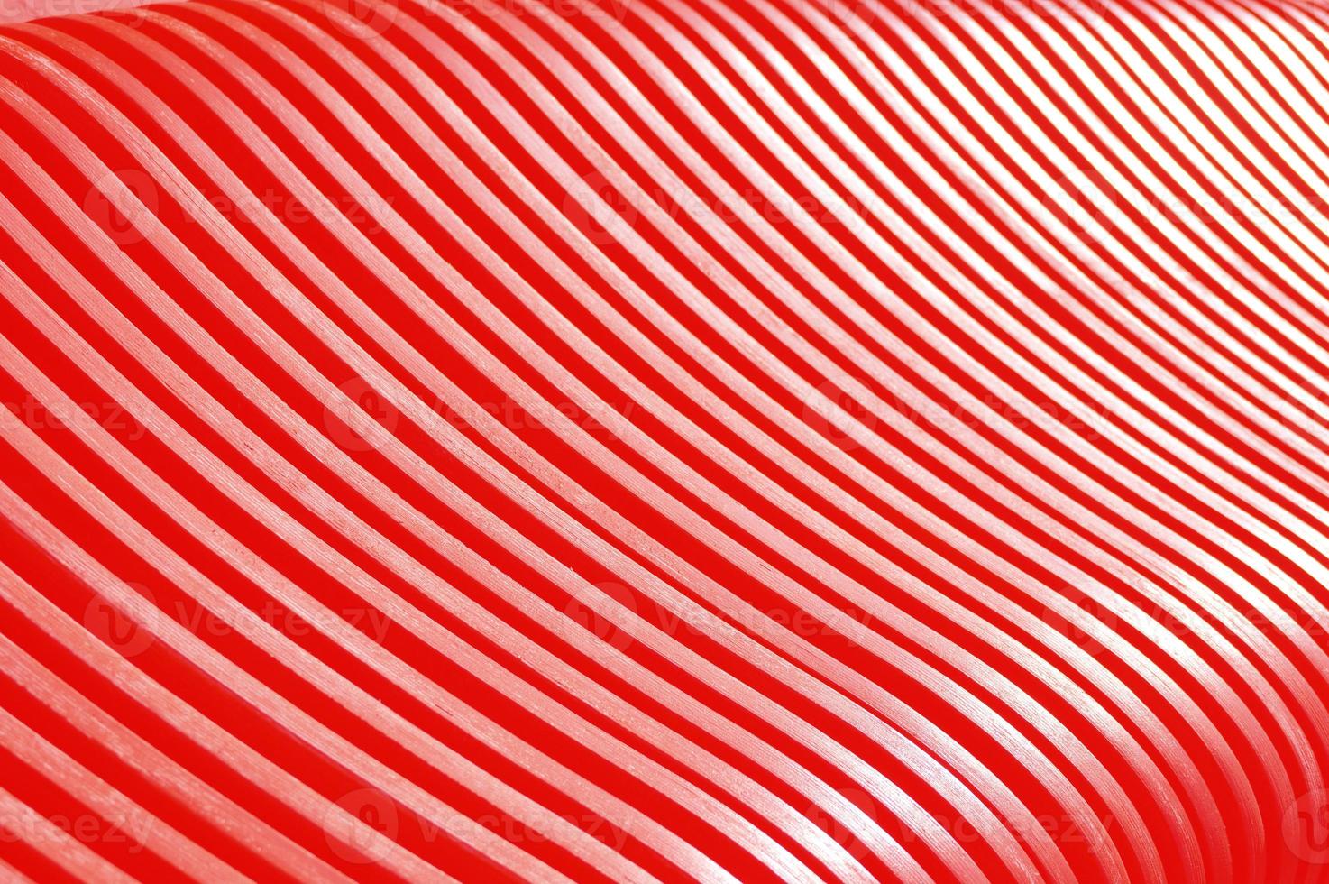 Red wooden slats. Abstract pattern with curved lines. Part of a bench, an element of building decoration. photo