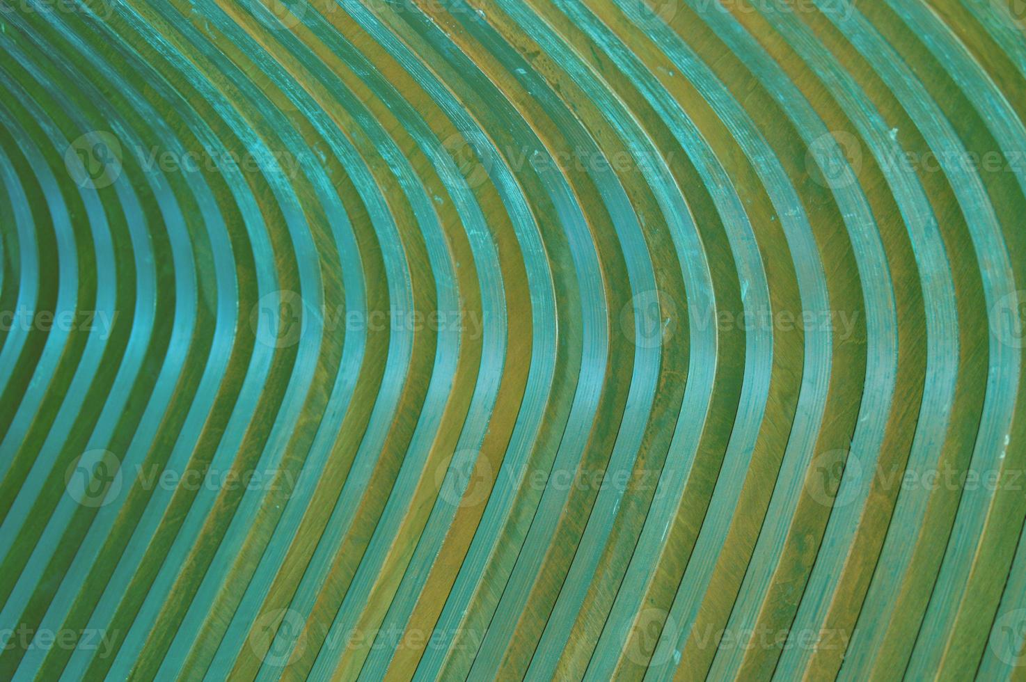 Wooden curved green slats. Abstract creative background. Glare of the sun on the surface. Building facade element. photo