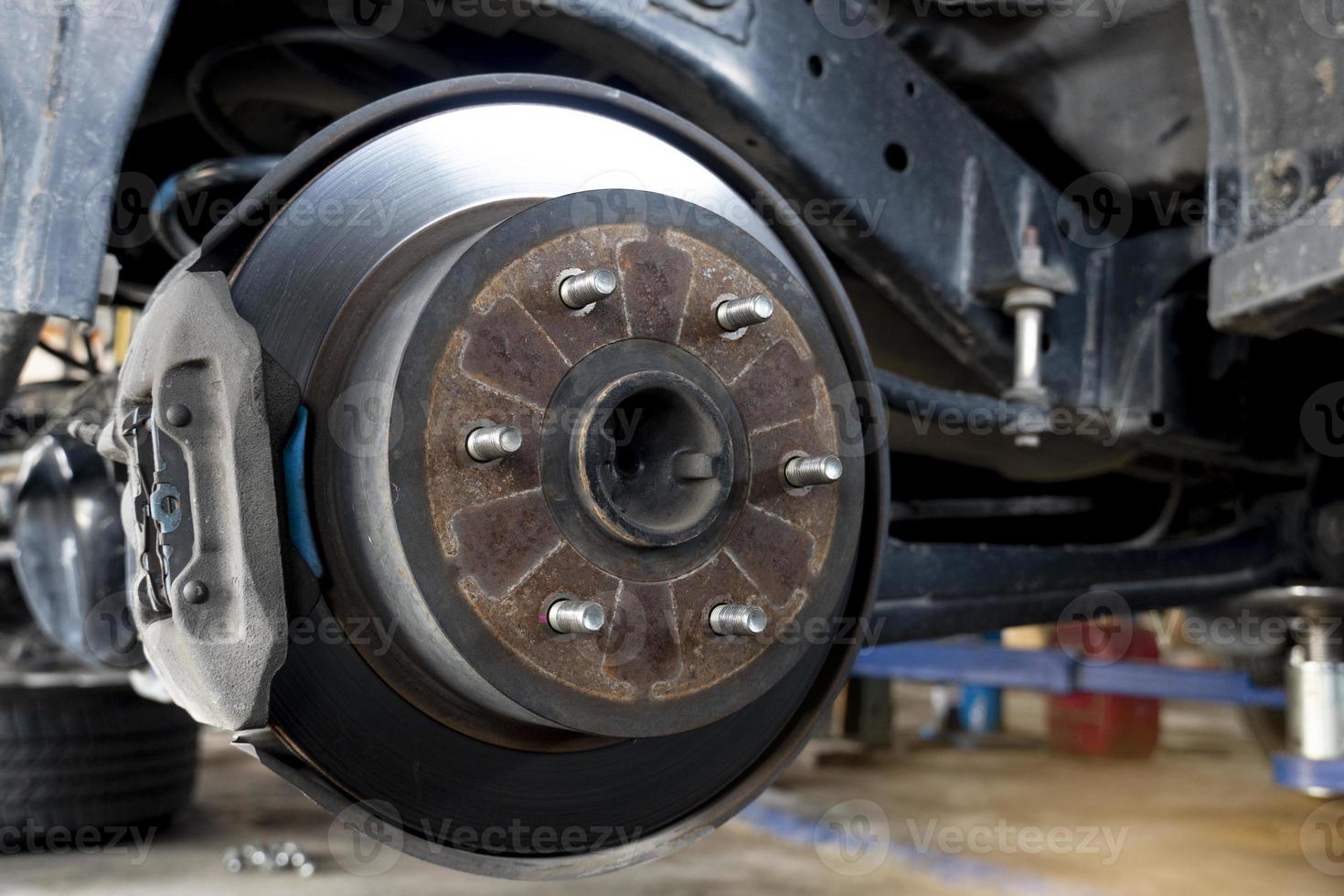 el fondo de mantenimiento de la suspensión del coche con las ruedas traseras quitadas revela los frenos de disco. foto