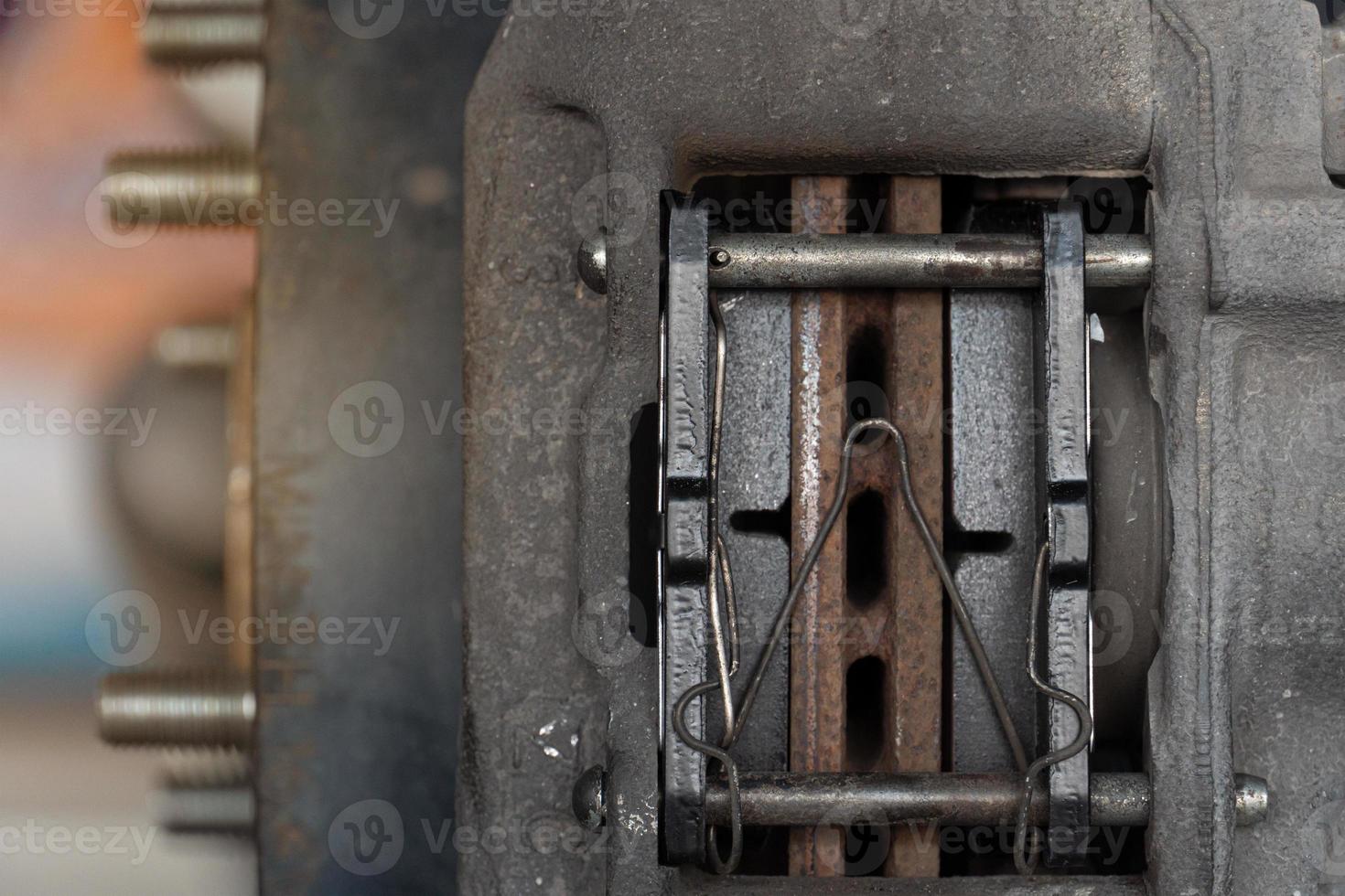 vista de primer plano del interior de una pinza con nuevas pastillas de freno. antecedentes de mantenimiento de automóviles. foto