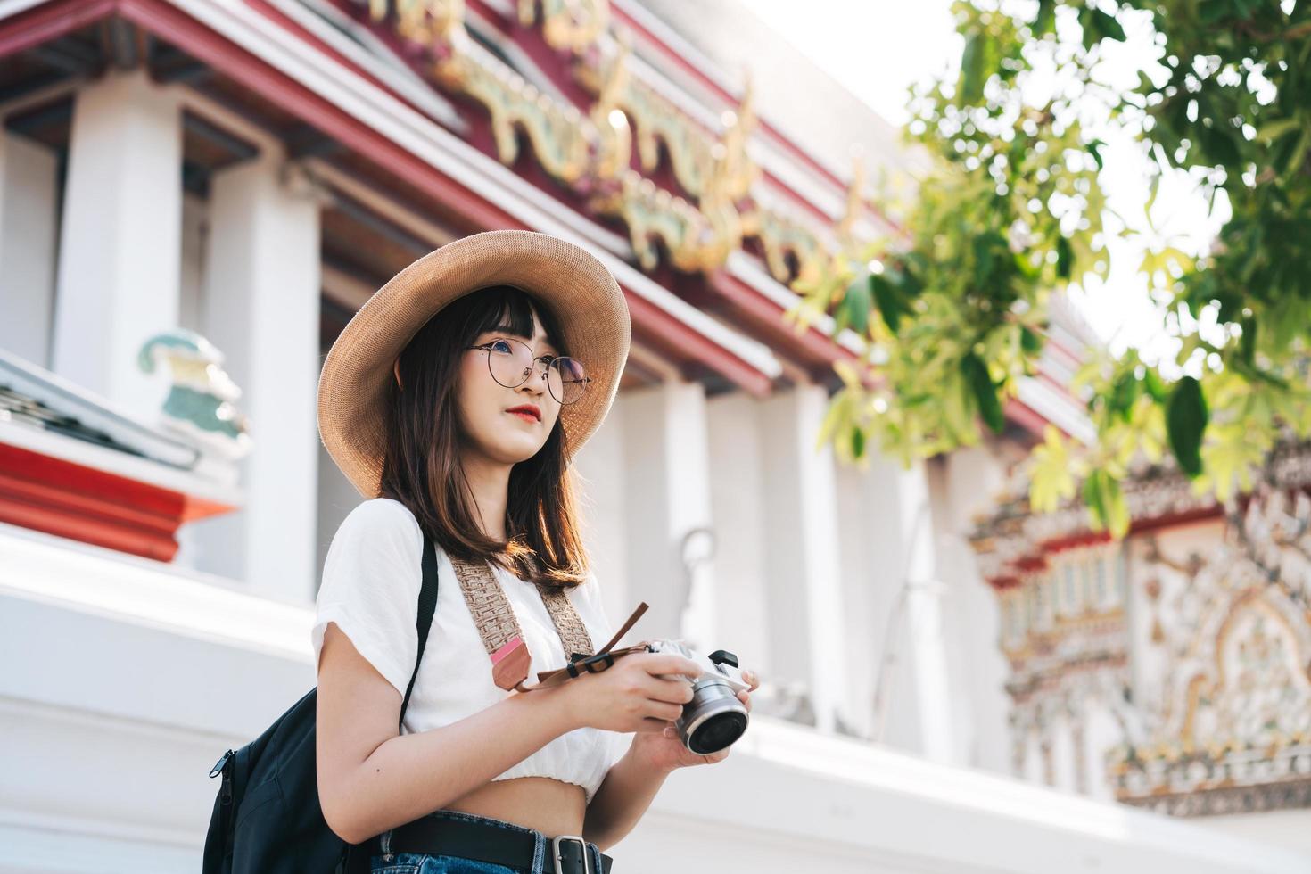 joven viajero asiático mujer adolescente mochila con cámara en bangkok. foto