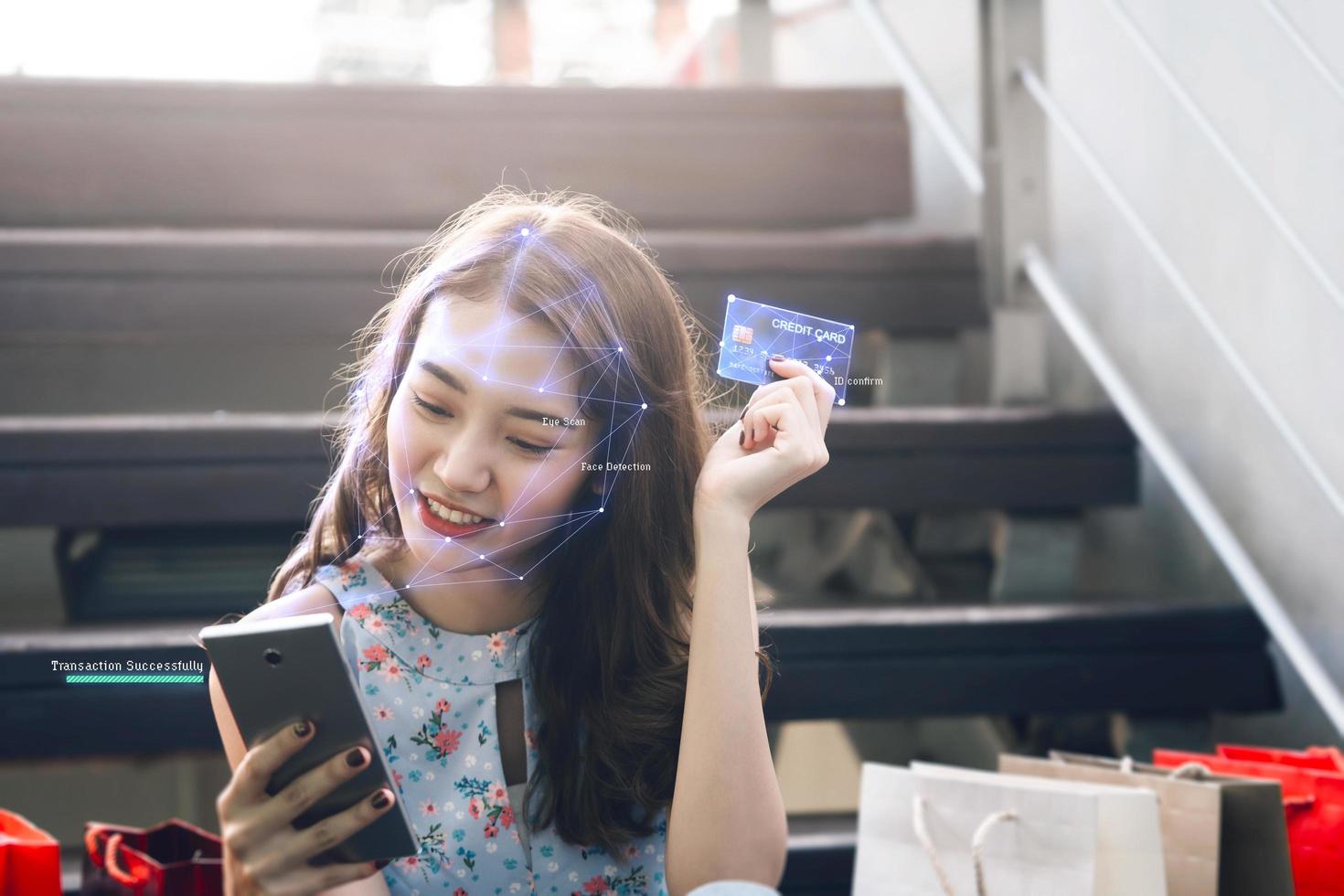 exploración facial de una mujer asiática adulta para comprar en línea con un teléfono móvil. foto