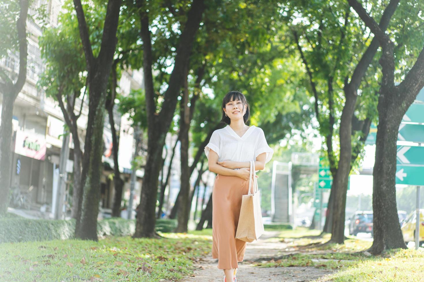 Young adult business asian woman walking in public park outdoor. photo