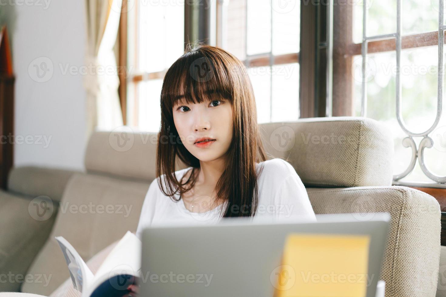 retrato mujer adolescente asiática leyendo un libro en casa. foto