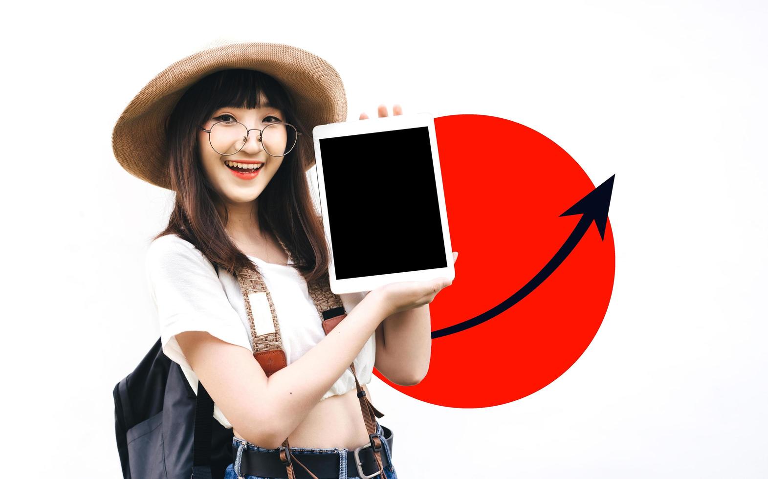 joven asiática con gafas de sonrisa sosteniendo un dispositivo de tableta para una pantalla simulada. foto