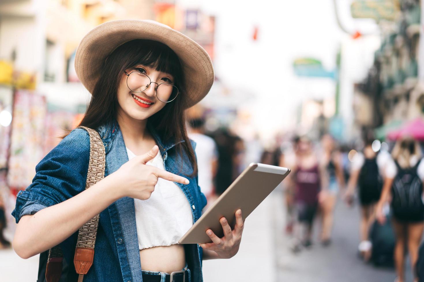 joven guía asiático usa dispositivo de tableta para viajes inteligentes. foto