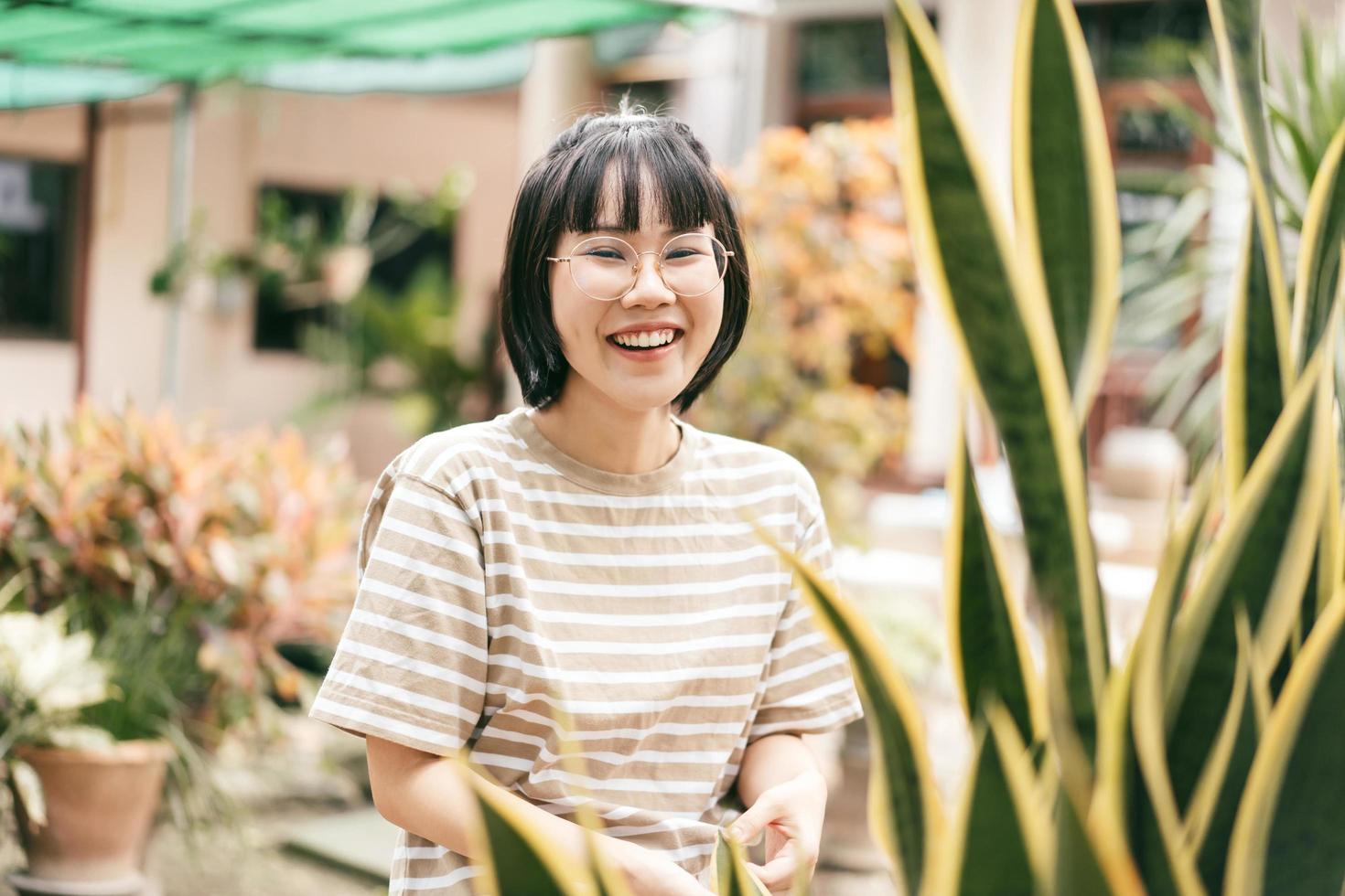 feliz joven mujer asiática adulta en el jardín de su casa el día. foto