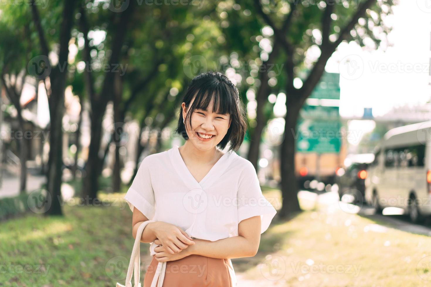 Young adult business asian woman walking in public park outdoor. photo