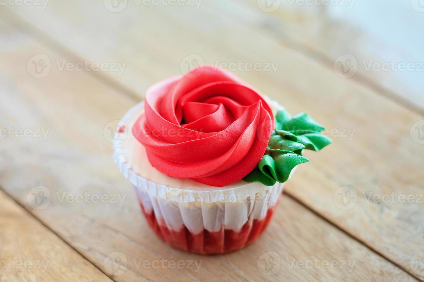 cupcake de rosa roja en la mesa de madera foto