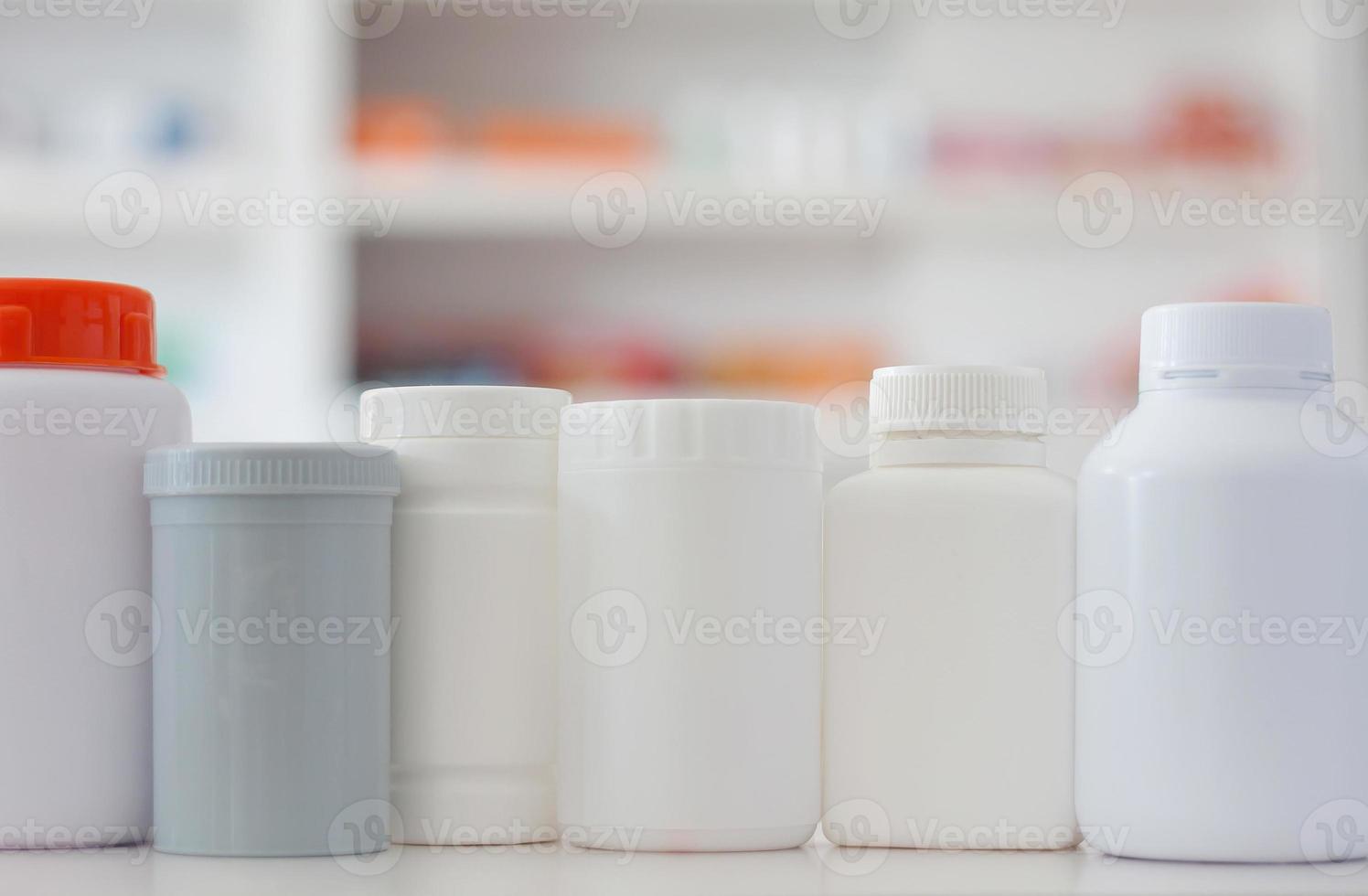 many medicine bottle with blur shelves of drug in the pharmacy drugstore background photo