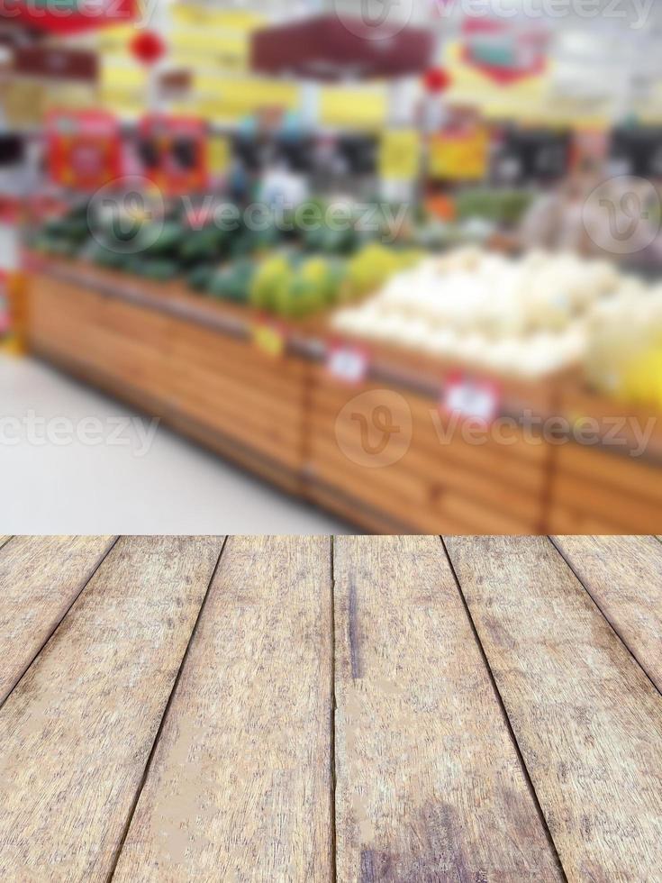 wood counter product display with fruits shelves in supermarket blurred background photo