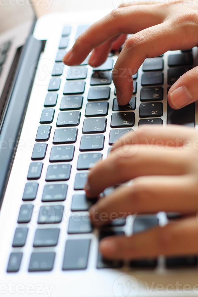 woman's hands typing on laptop keyboard photo