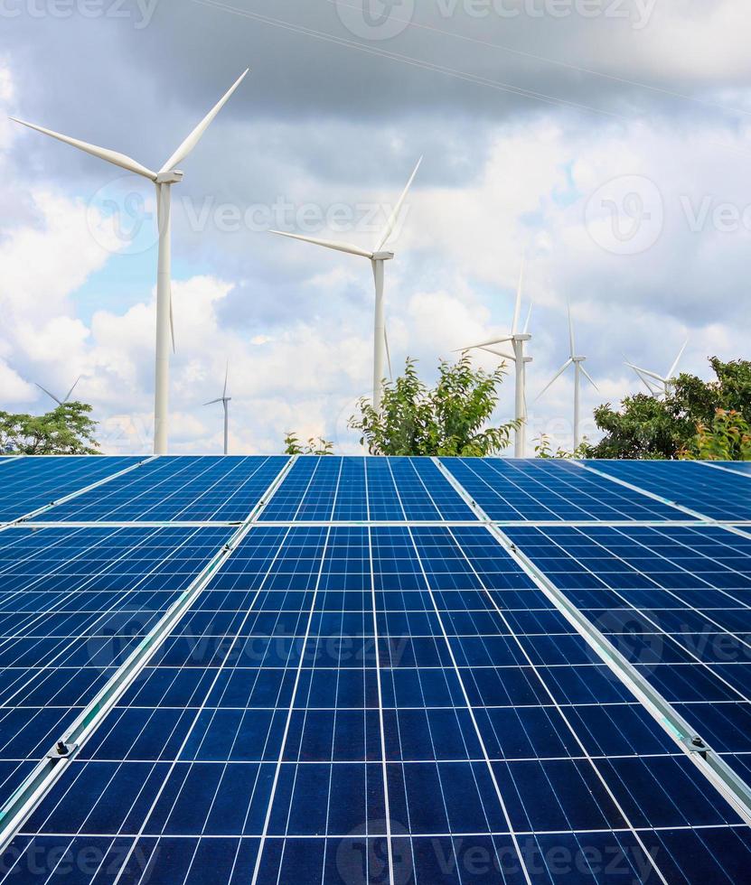 solar panels and wind turbines with the clouds and sky photo