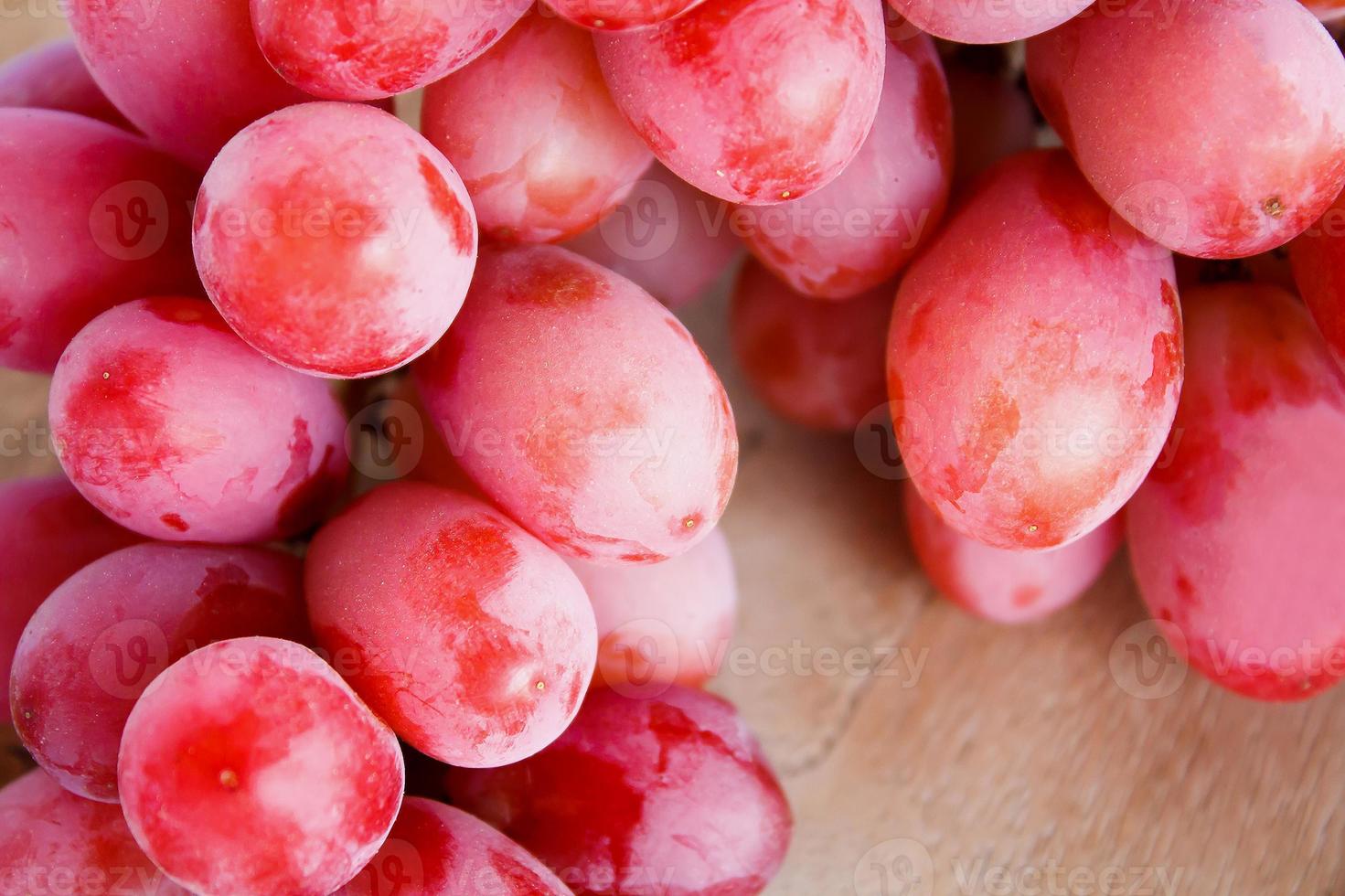 close up red grapes on wooden background photo