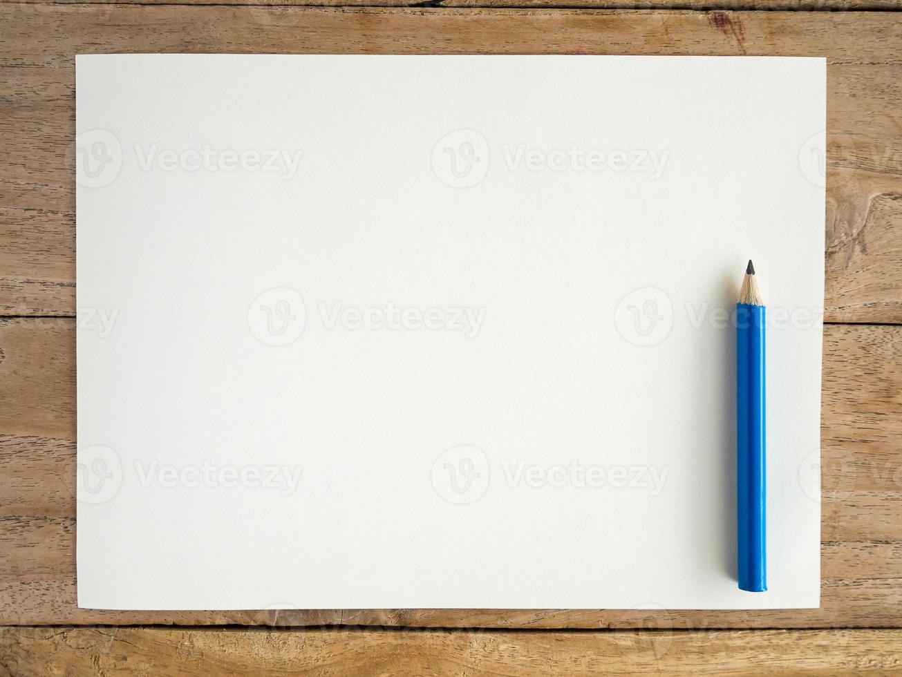 Blank paper with pencil on wood table photo