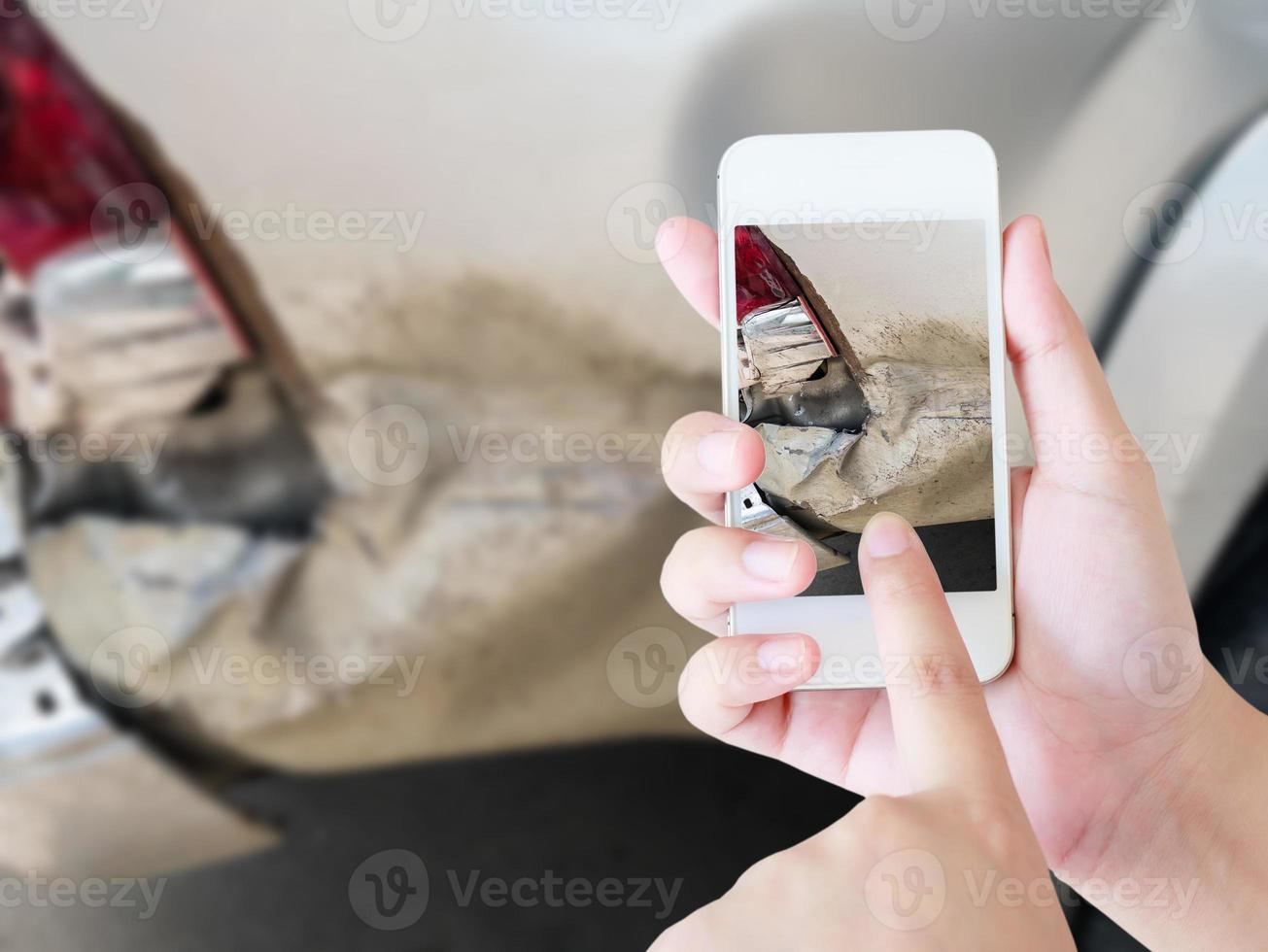 woman using smart phone to take car damage photo