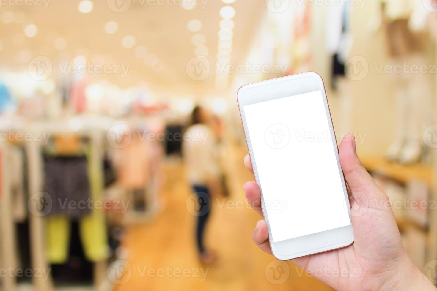 mujer usando celular en tienda de ropa foto