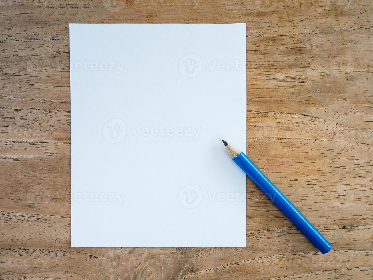 Blank paper with pencil on wood table photo