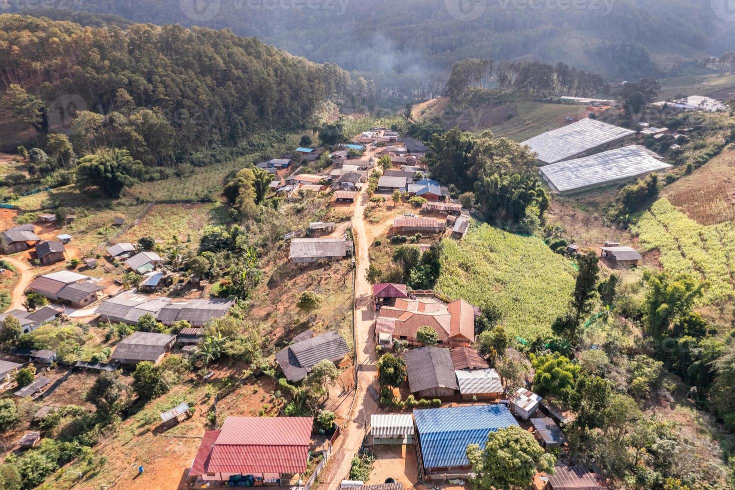 vista aérea de la aldea rural local en el valle en el campo lejano entre la selva tropical foto