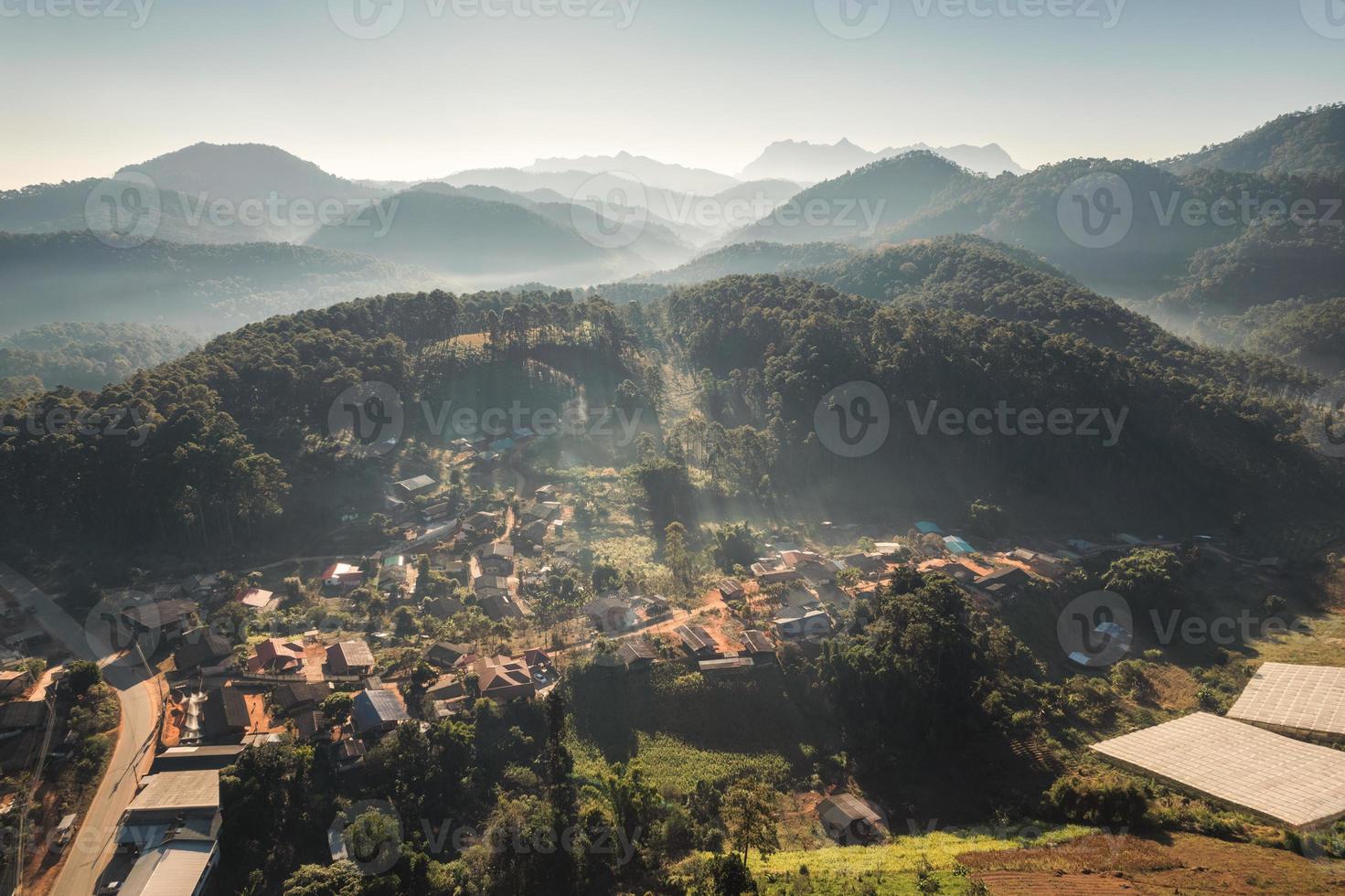 vista aérea de la aldea tradicional de la tribu en la niebla entre el valle y la capa montañosa por la mañana foto