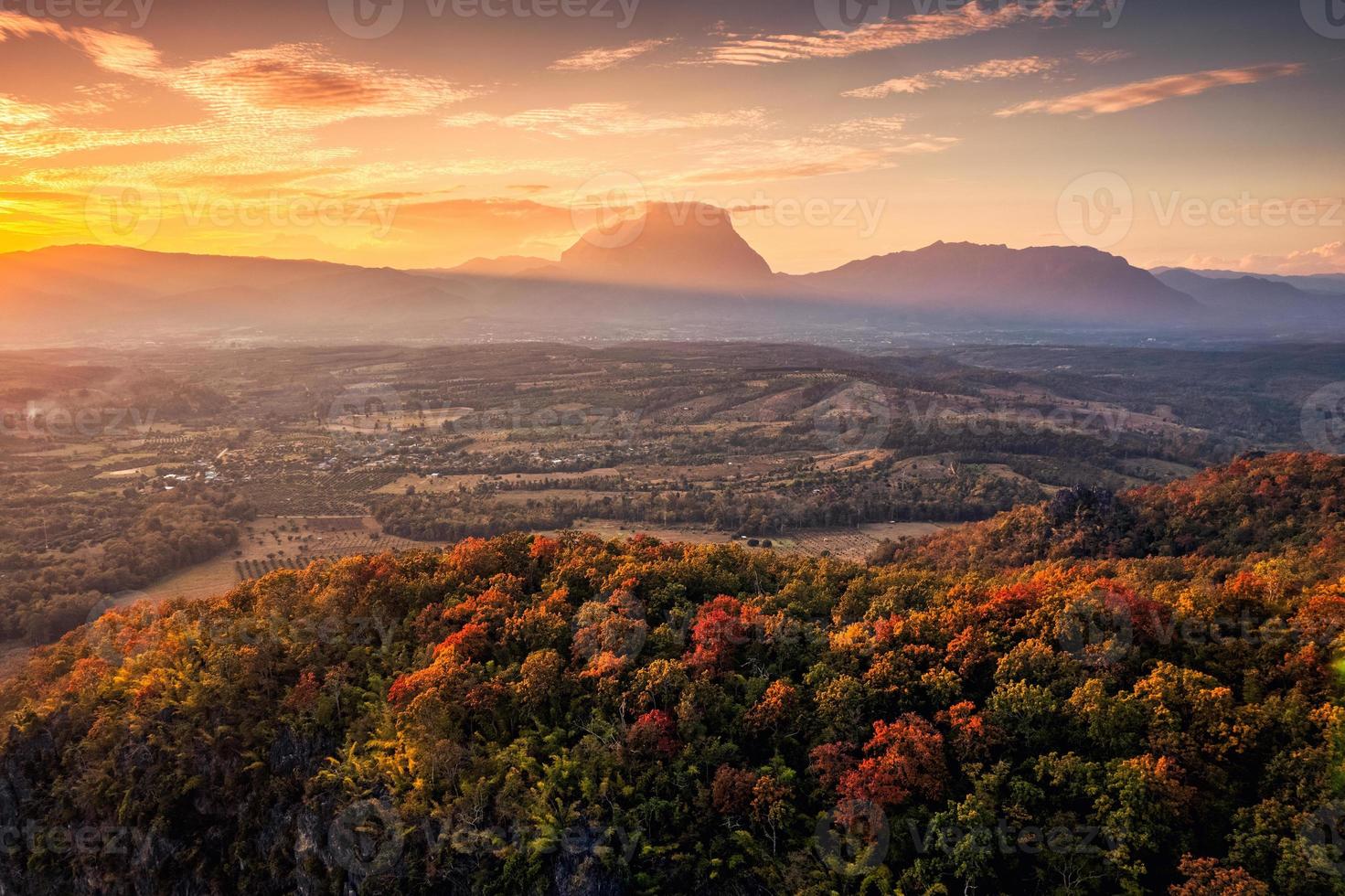 Sunset over mountain range with colorful autumn forest on hill in countryside photo