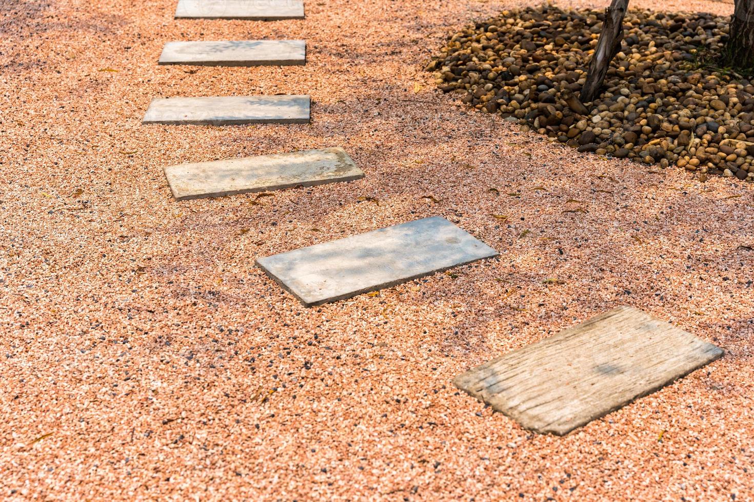 Zen stone path on gravel floor in the garden photo