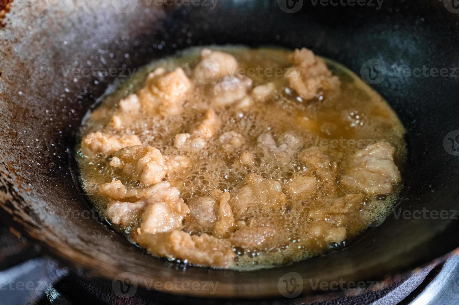 Frying crispy fried chicken meat with boiling oil in fry pan on gas stove photo
