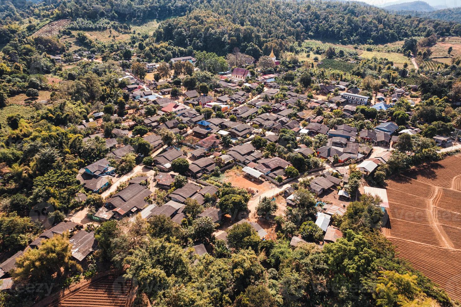 Aerial view of local rural village in the valley on faraway at countryside among the tropical rainforest photo