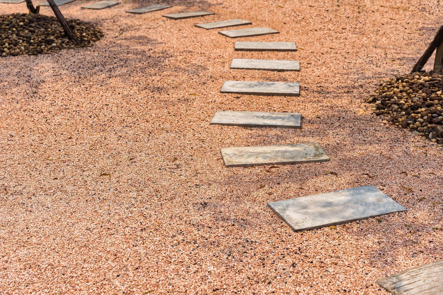 Zen stone path on gravel floor in the garden photo