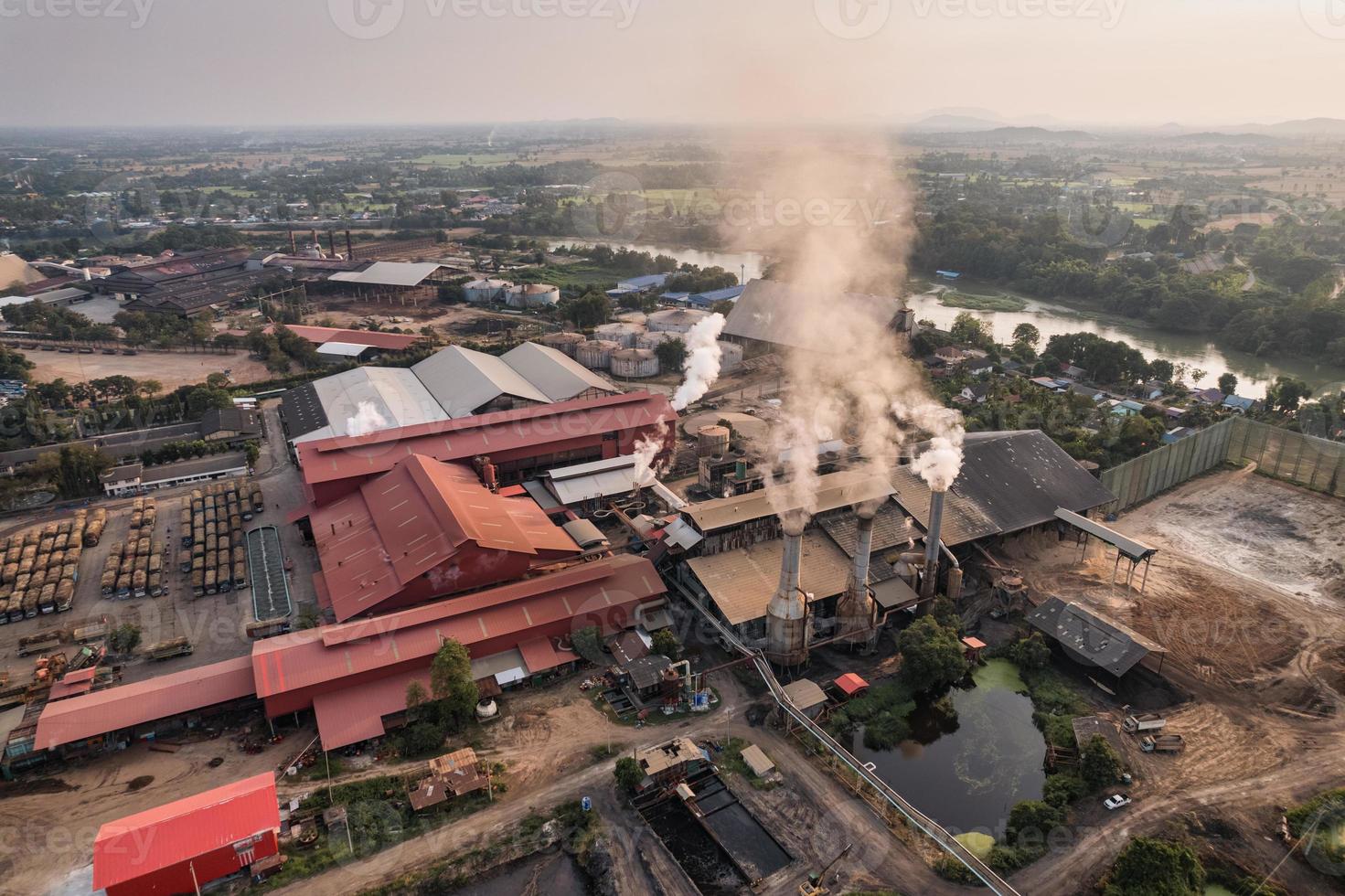 Sugar bioethanol translation factory working with steam from the chimney and sugarcane truck photo