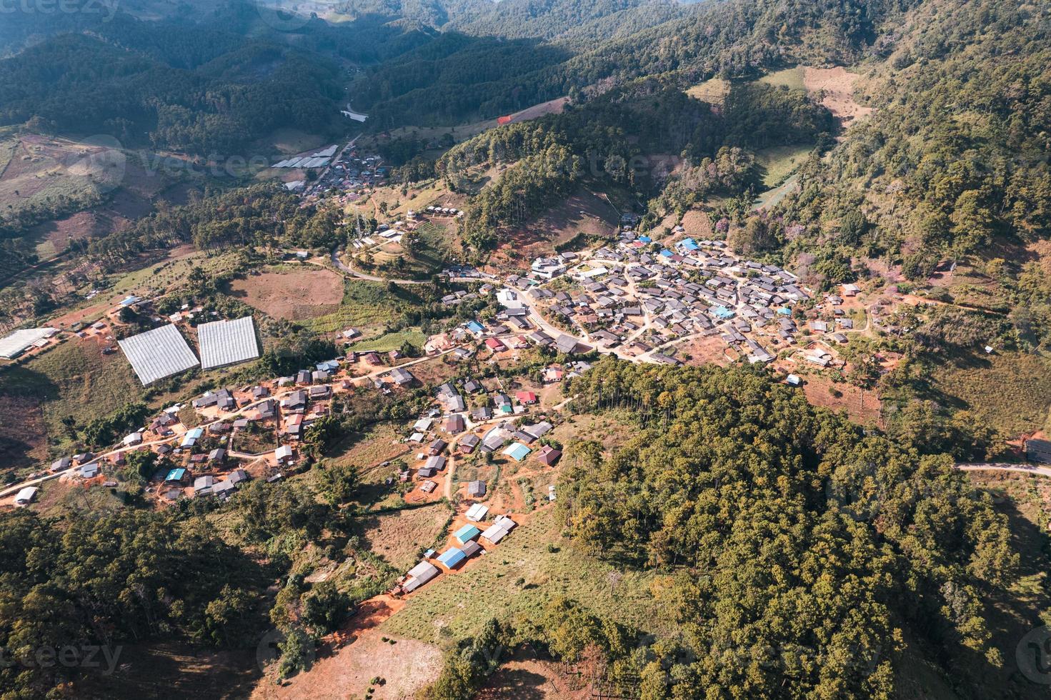 vista aérea de la aldea rural local en el valle en el campo lejano entre la selva tropical foto