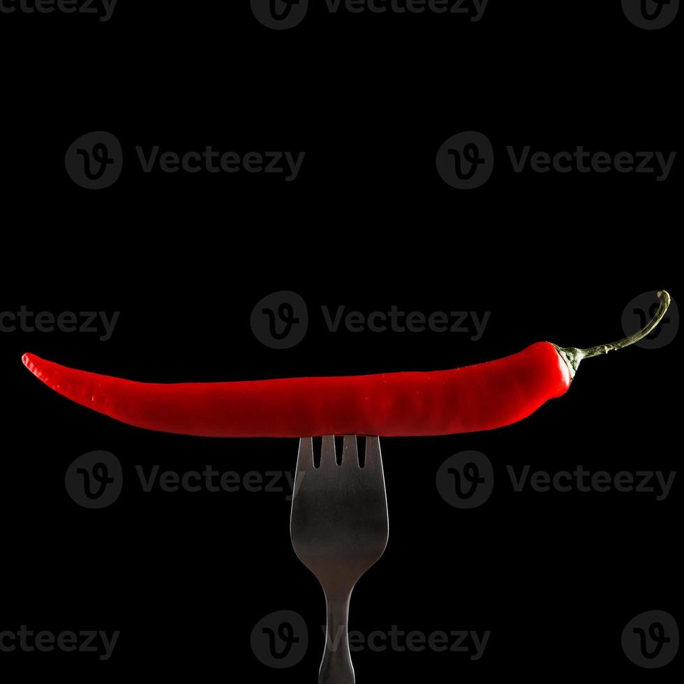 Fork and chili pepper on it photo